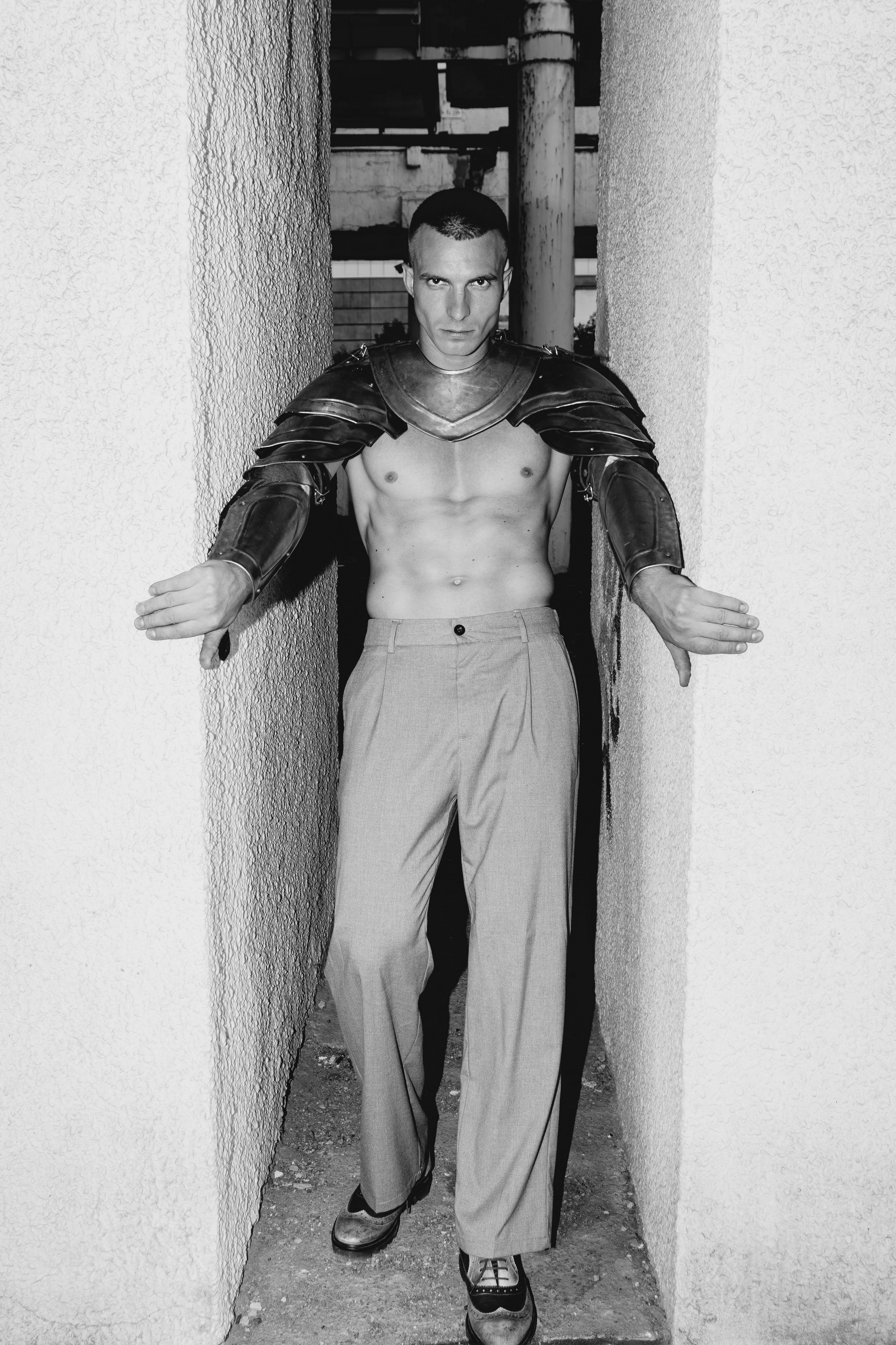 Чёрно белая фотография мужчины в доспехах между белых стенок