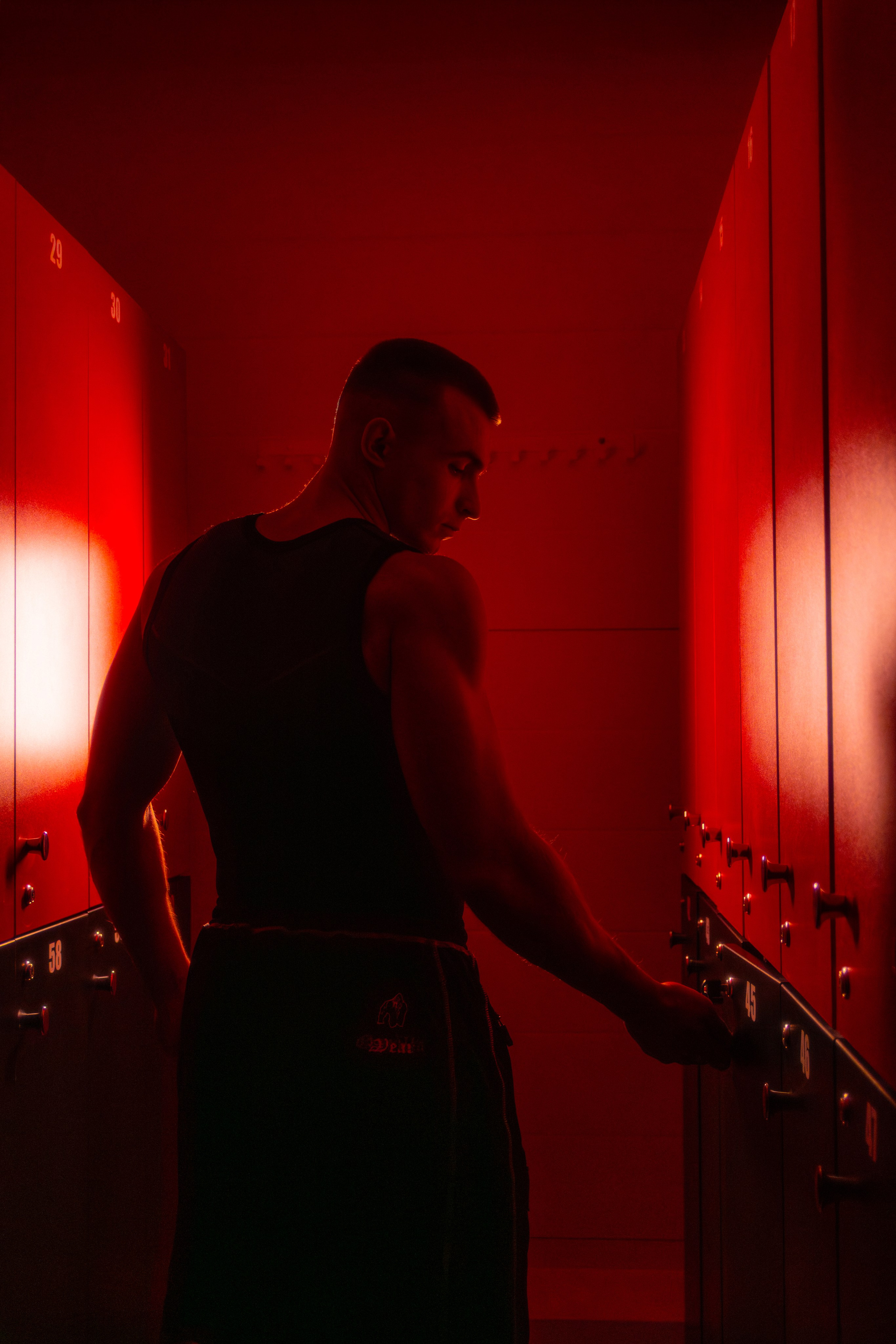 Модный кадр фитнес-инструктора в ночном клубе спорта, где свет подчеркивает красоту атлетического телосложения.