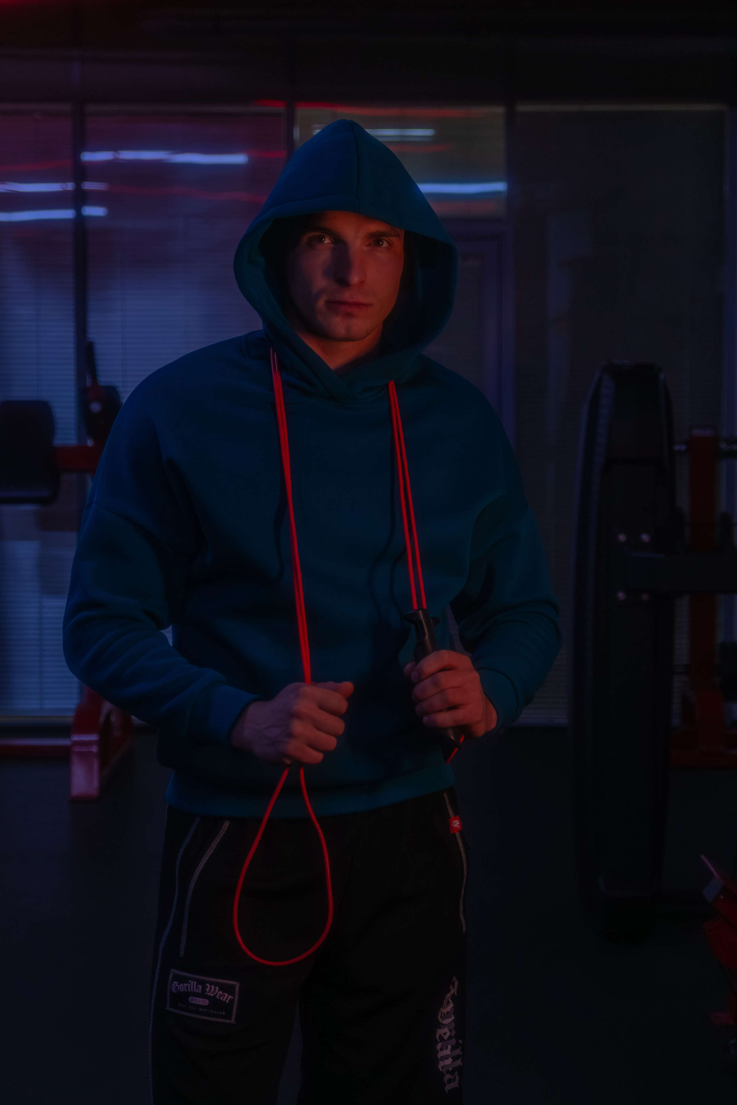 Журнальный портрет фитнес-эксперта в современном зале, где свет акцентирует внимание на рельефе мышц.