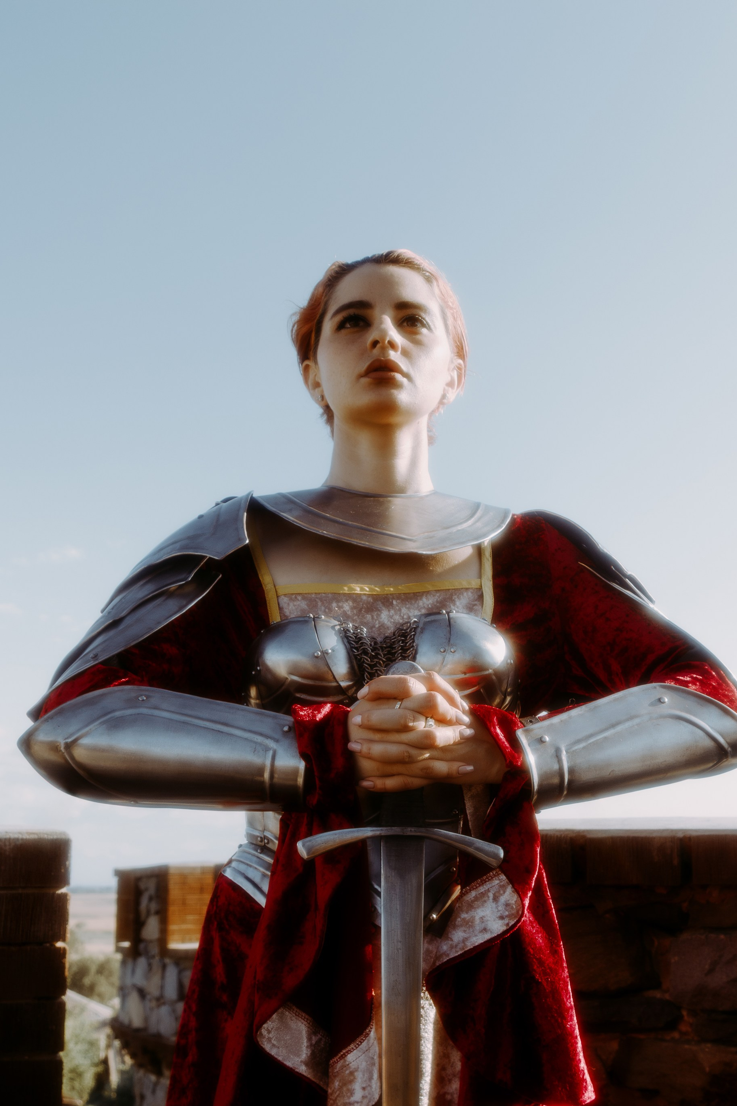 Королева в стоит на крыше замки и держит в руках рыцарский меч