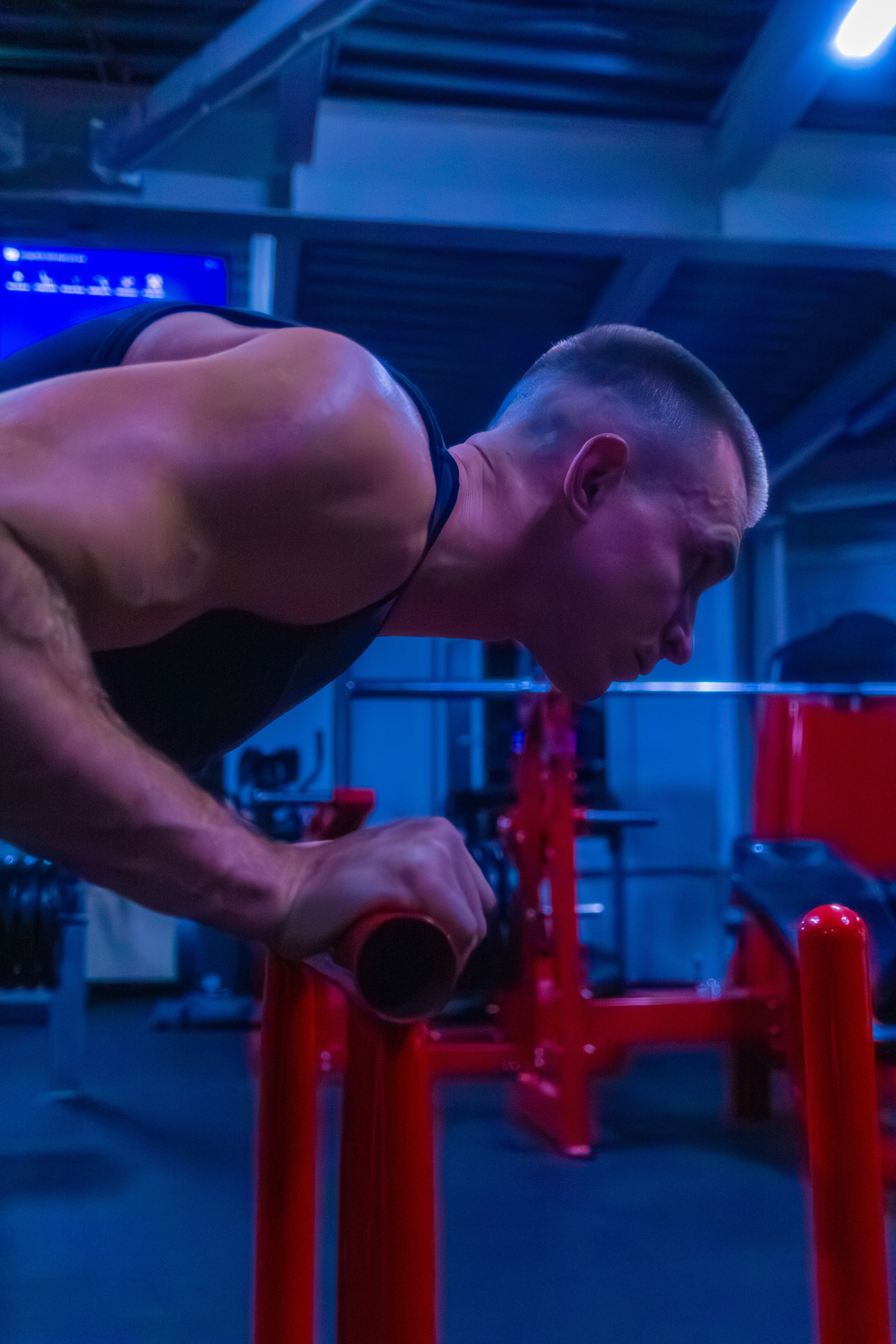 Журнальный портрет тренера в современном зале, подчеркивающий мощь тела.