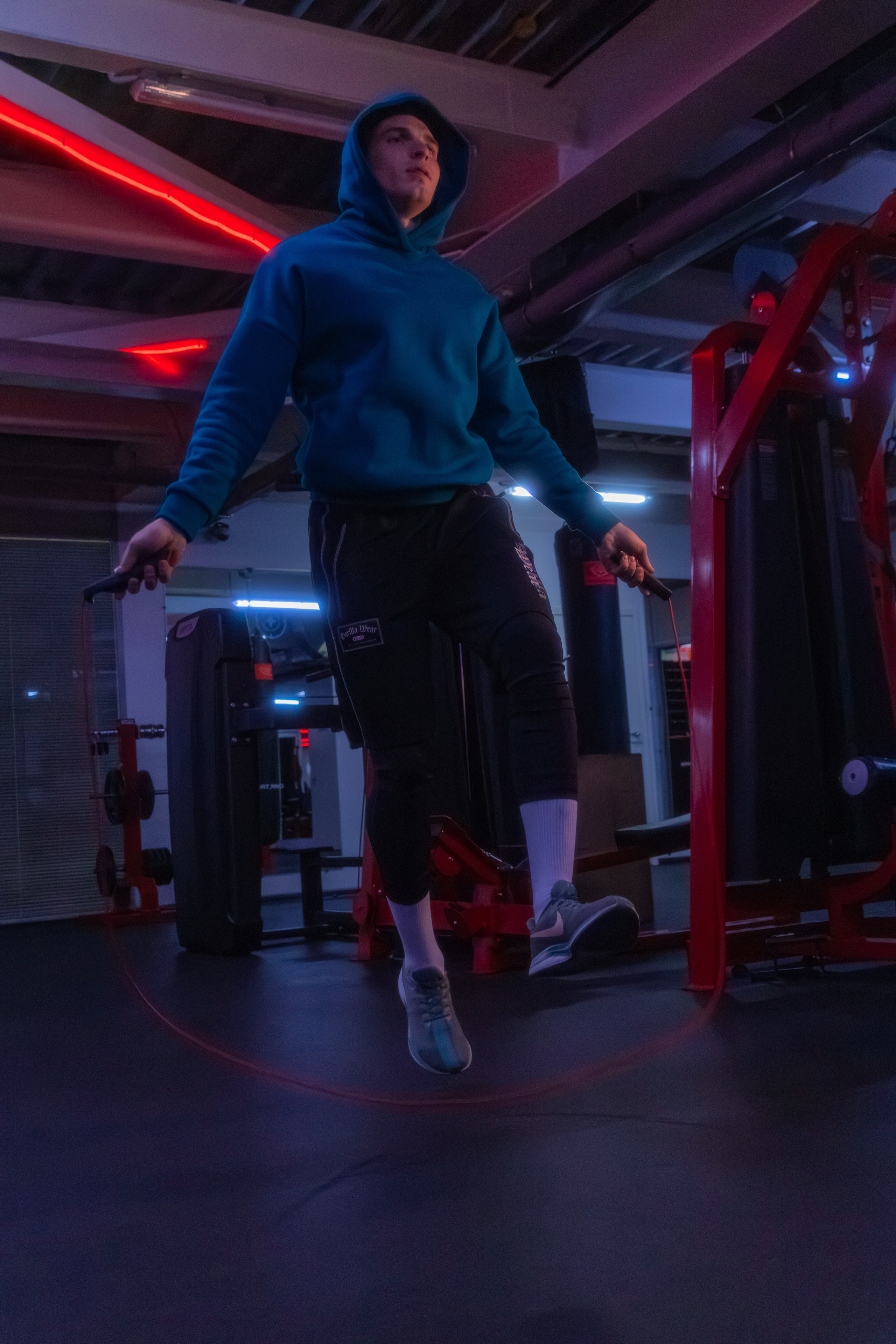 Профессиональная съемка спортивного наставника, где неоновые огни создают драматический эффект.