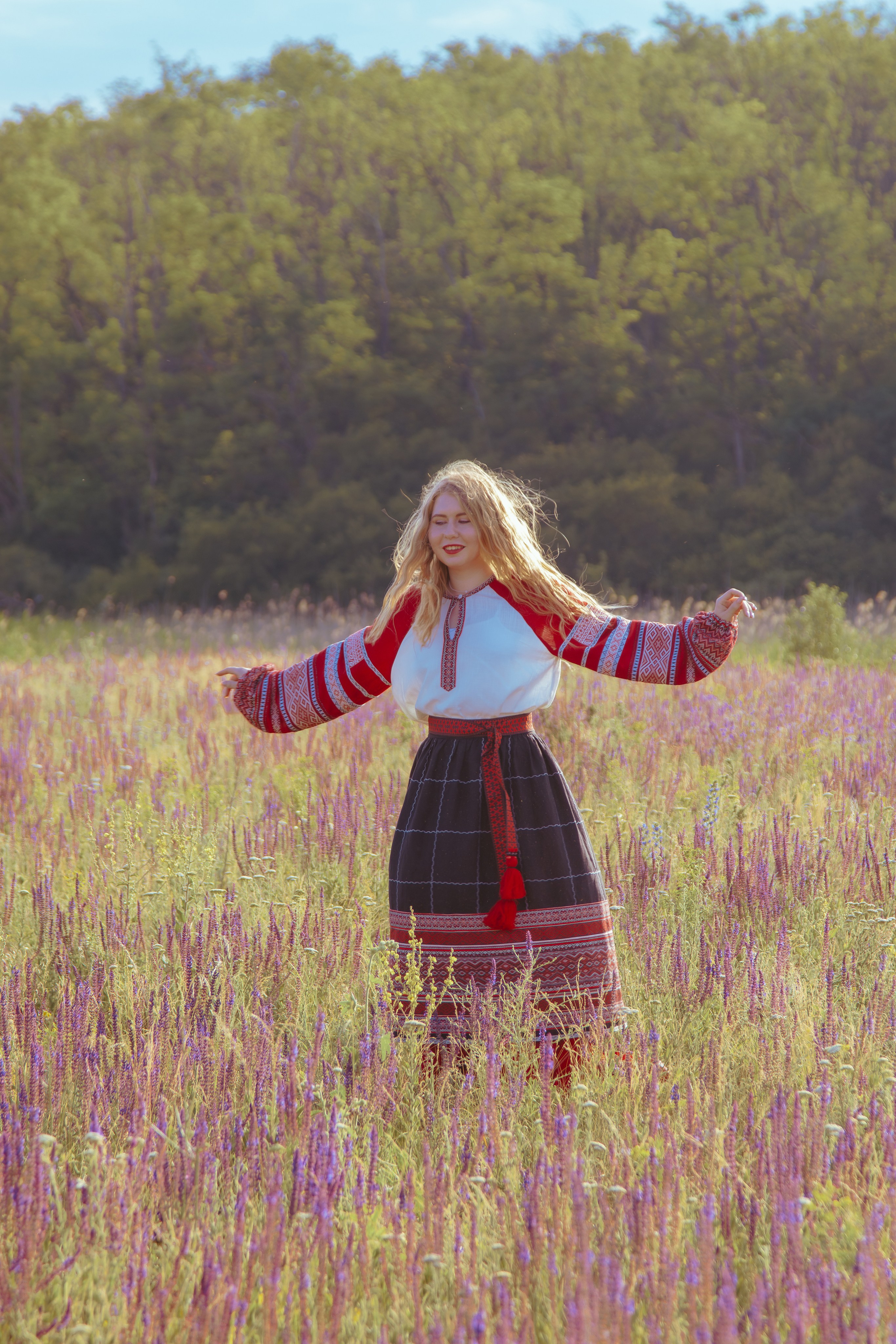 народная девушка танцует на фоне леса и неба
