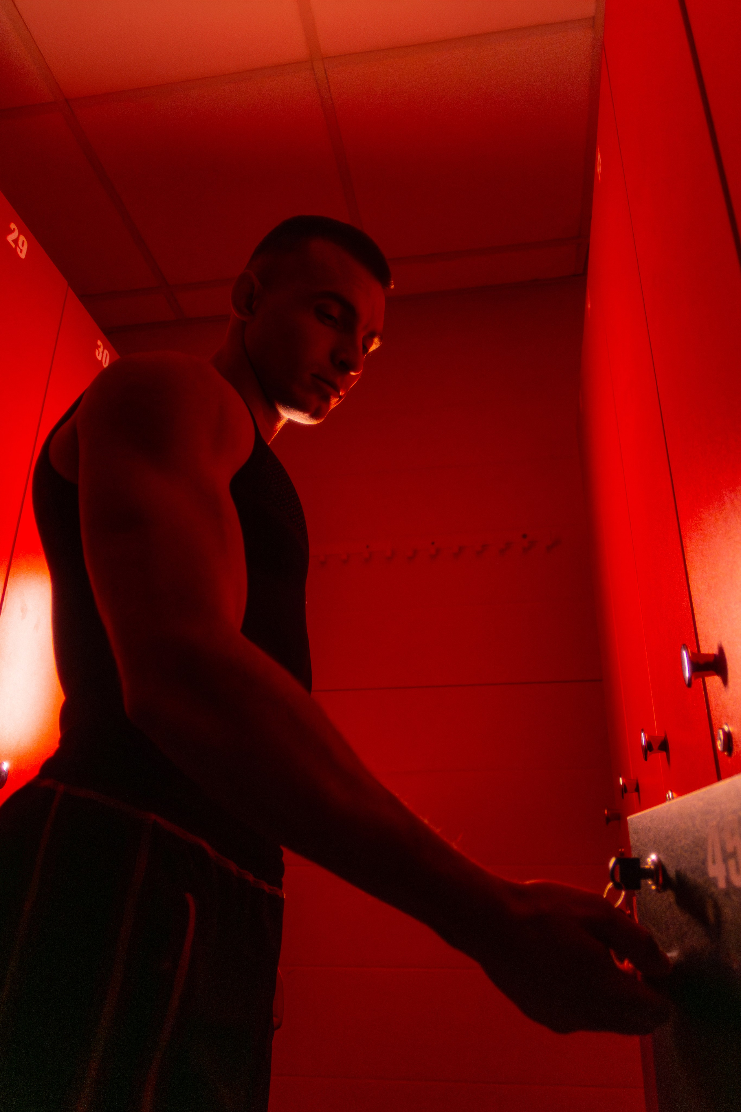 Стильный журнальный снимок спортивного тренера в современном зале, где цветной свет создает атмосферу роскоши и успеха.