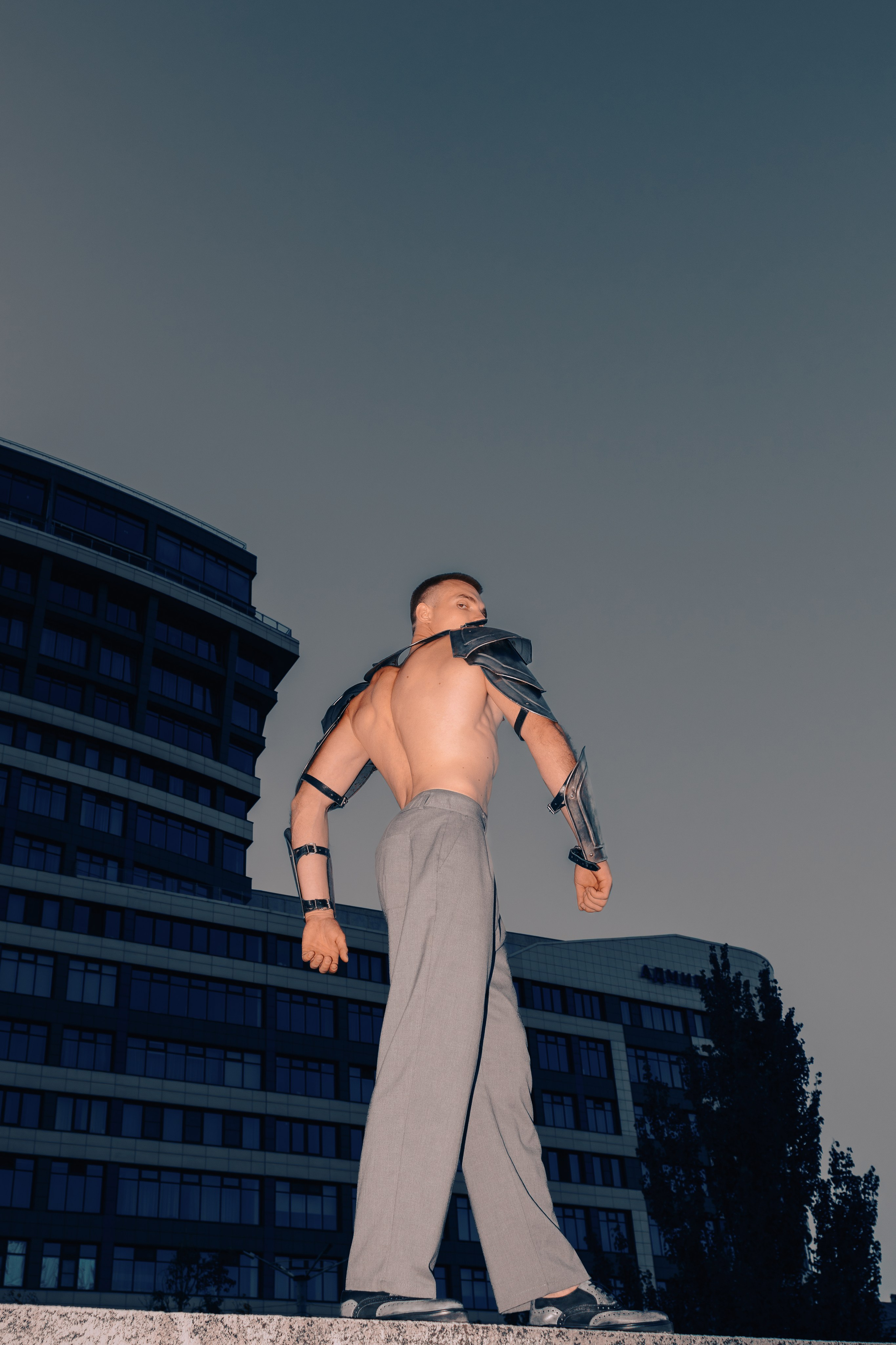 Эстетика мужского тела в рыцарских доспехах. Мужчина стоит спиной к камере