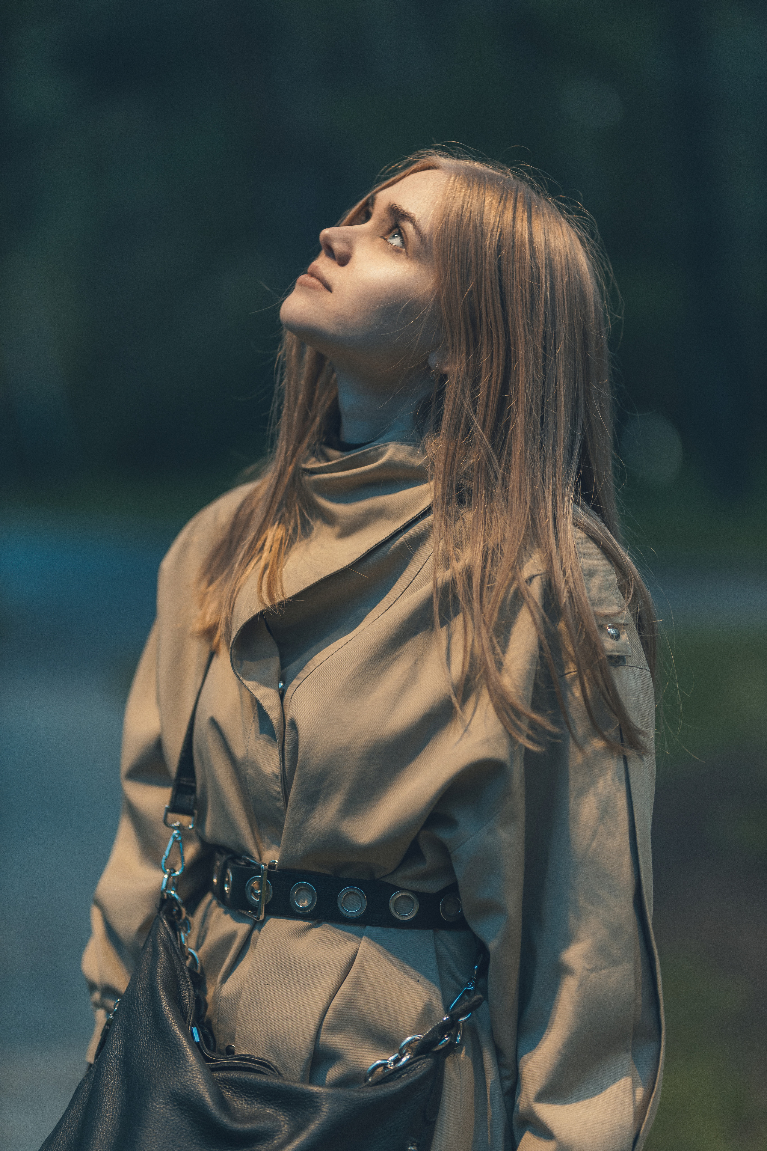 Женский портрет в парке с поднятым лицом к небу, профессиональная съёмка с глубокими тенями