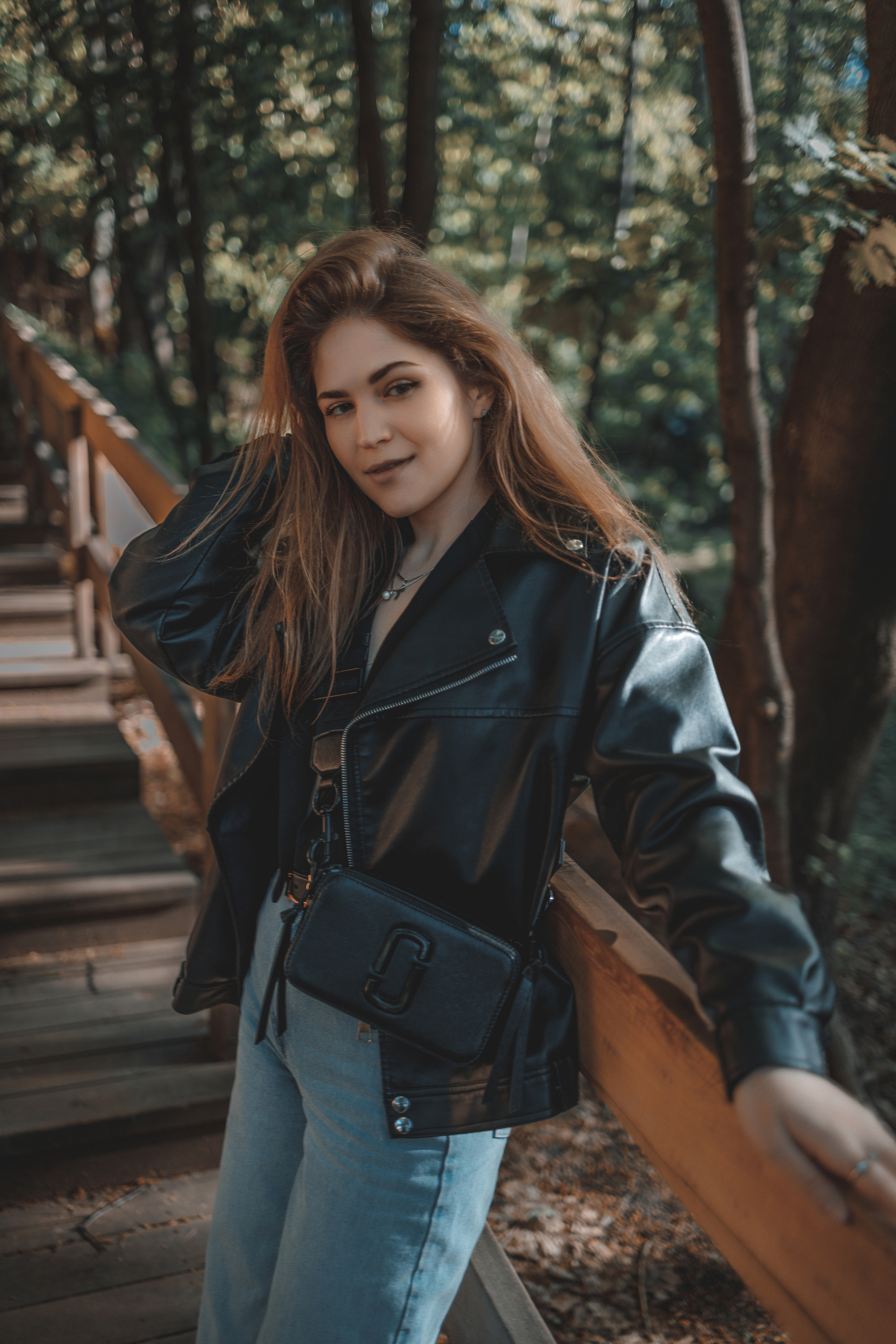 уличная фотосессия в парке с девушкой в кожаной куртке