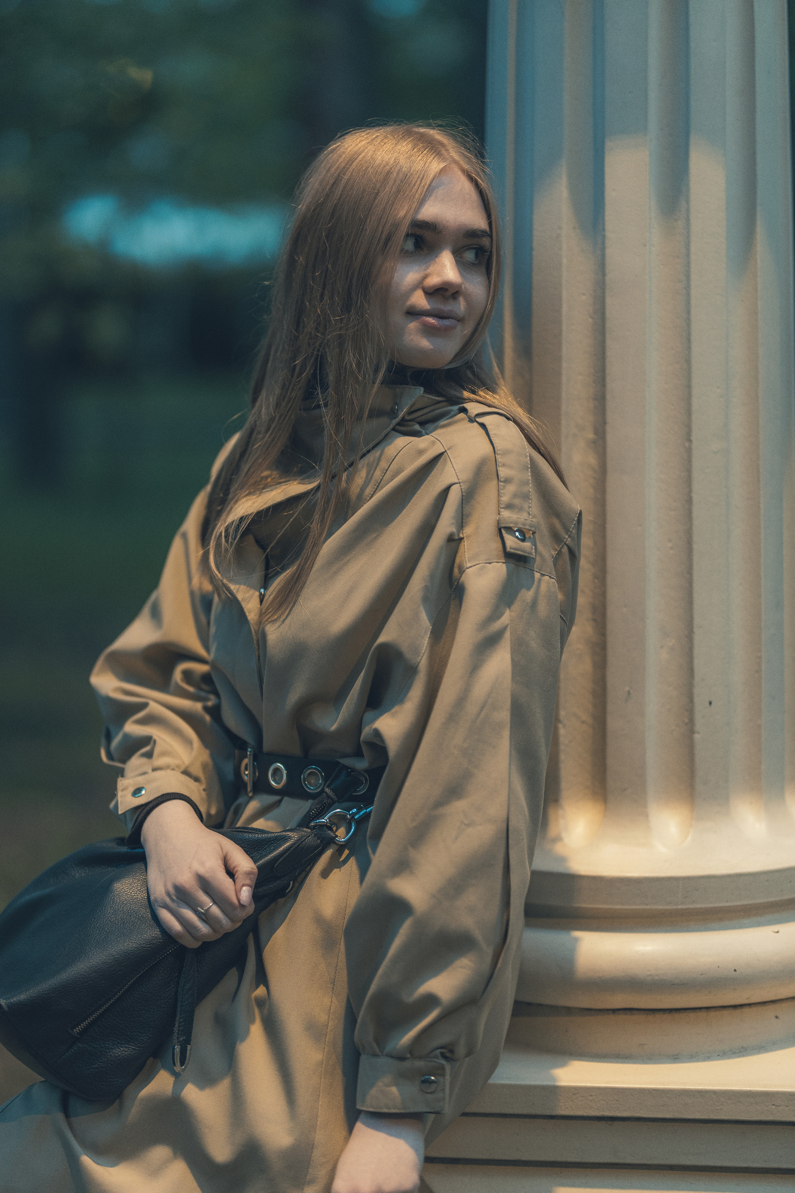 Креативная портретная съёмка девушки в тренче на фоне колонн, естественный свет, профессиональная работа