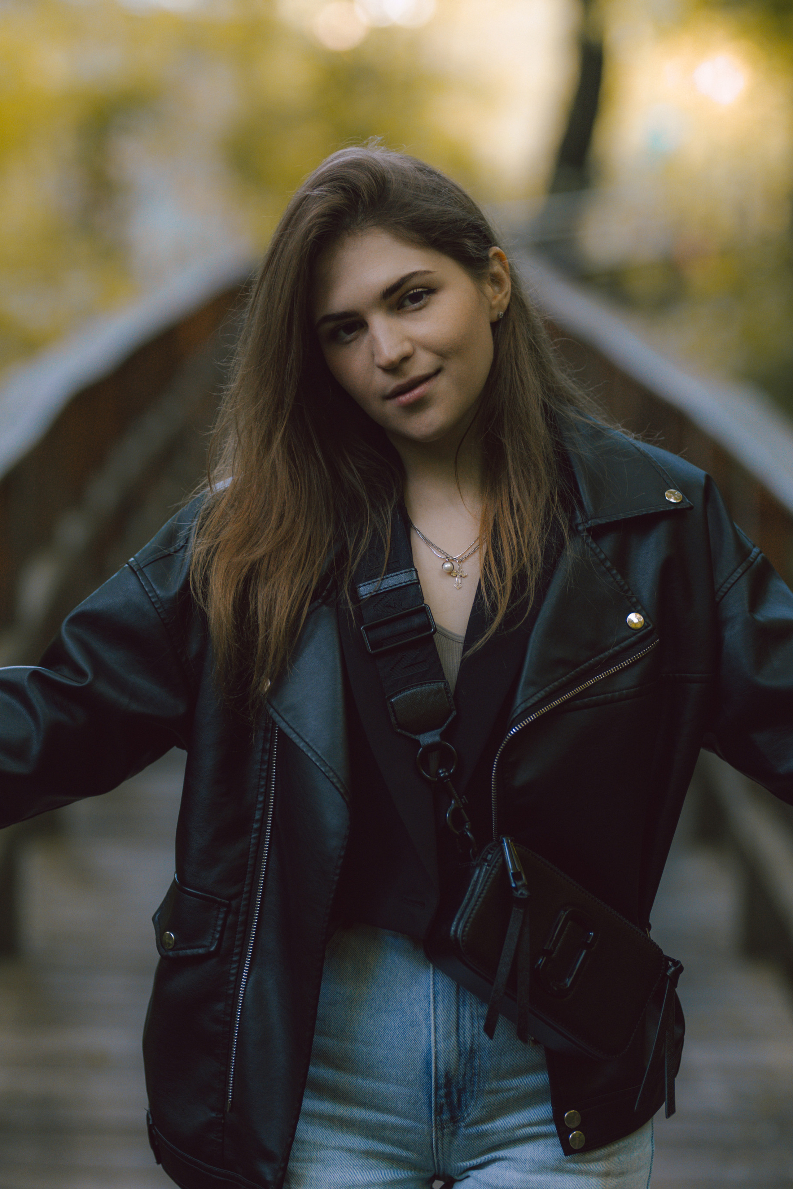 уличная фотосессия осенью, девушка в кожанке смотрит в камеру