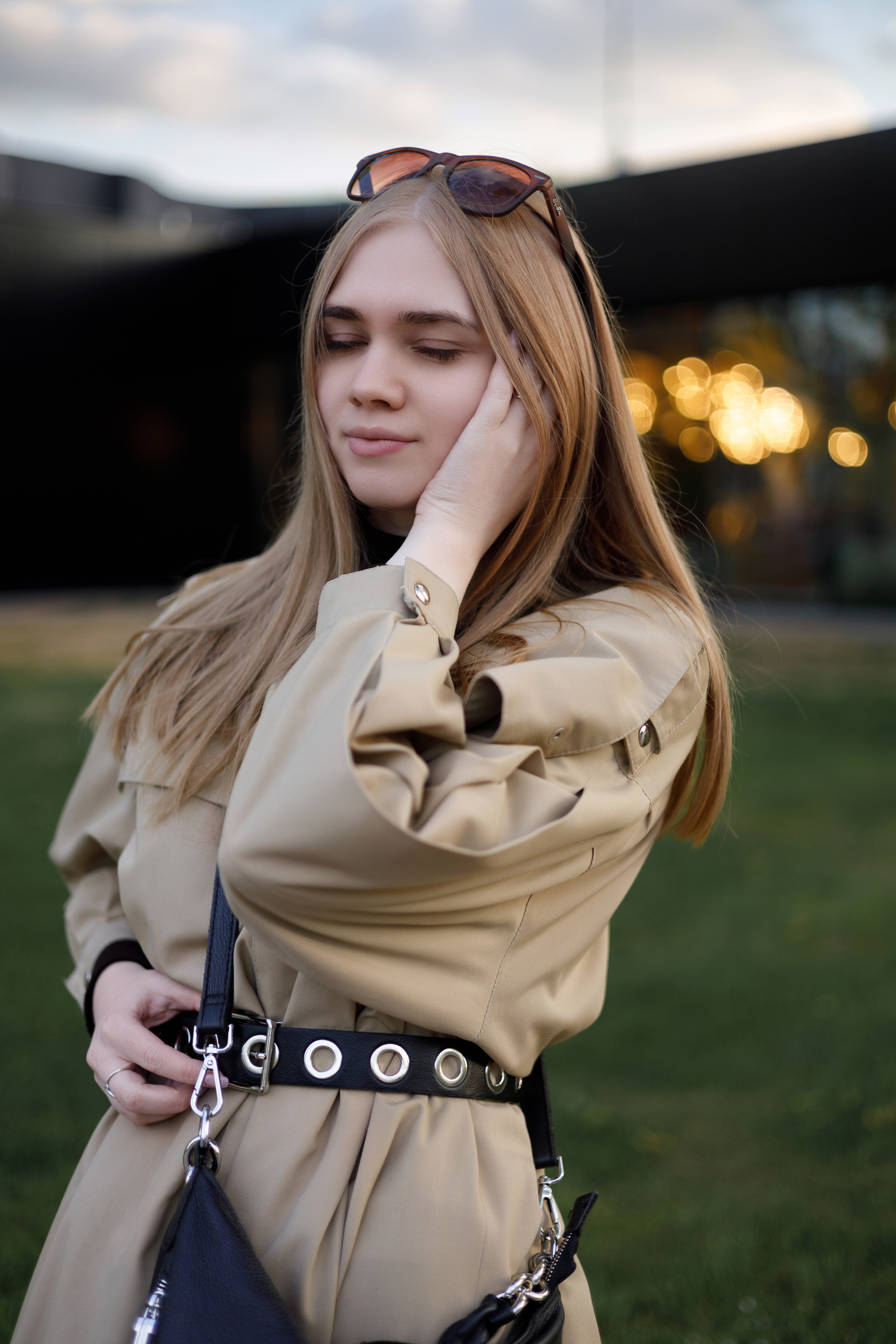 Профессиональный портрет молодой женщины в бежевом плаще, съёмка с акцентом на естественное освещение