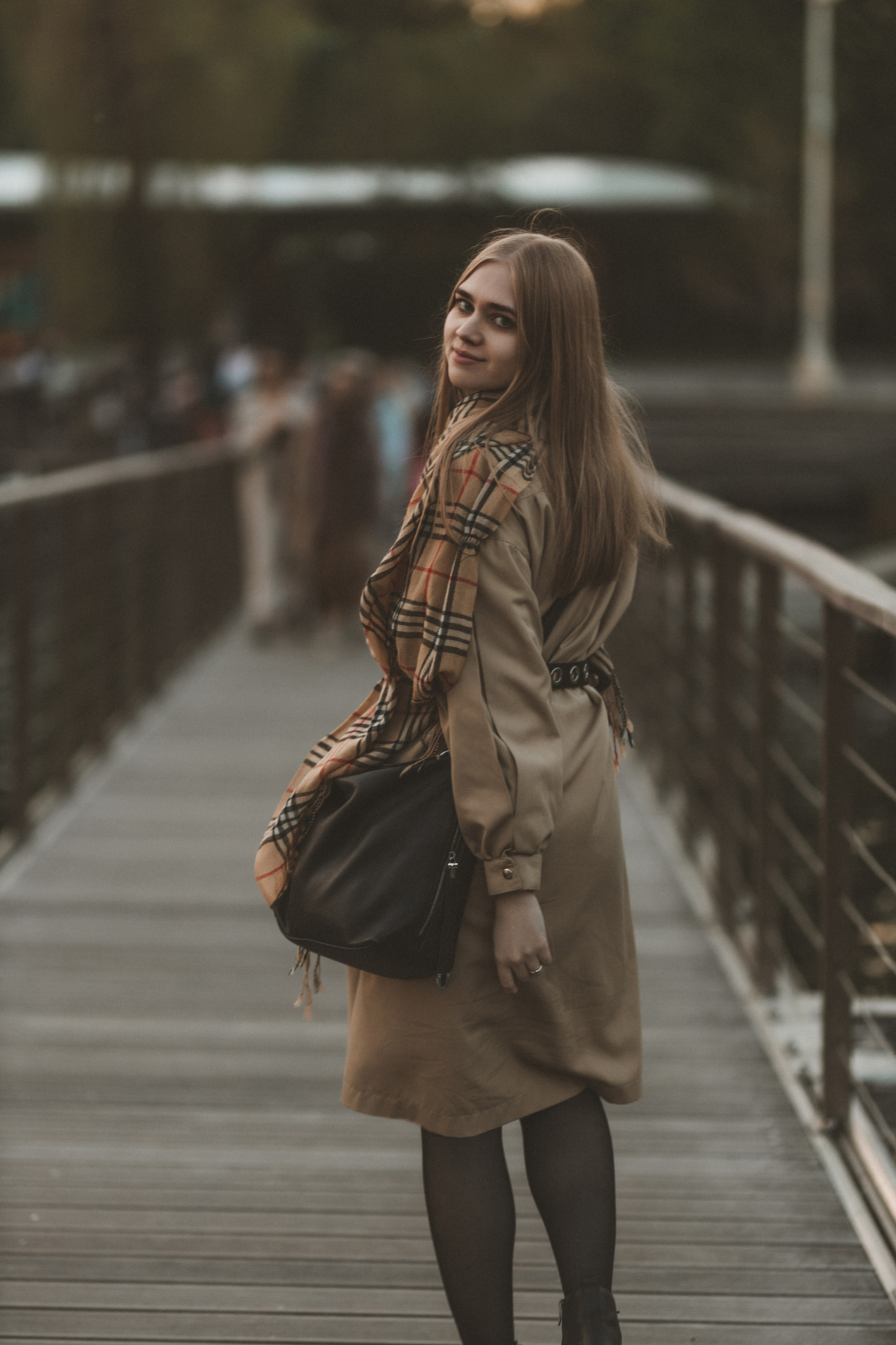 Атмосферный портрет девушки в парке на мосту, естественное освещение, профессиональная съёмка с акцентом на природу