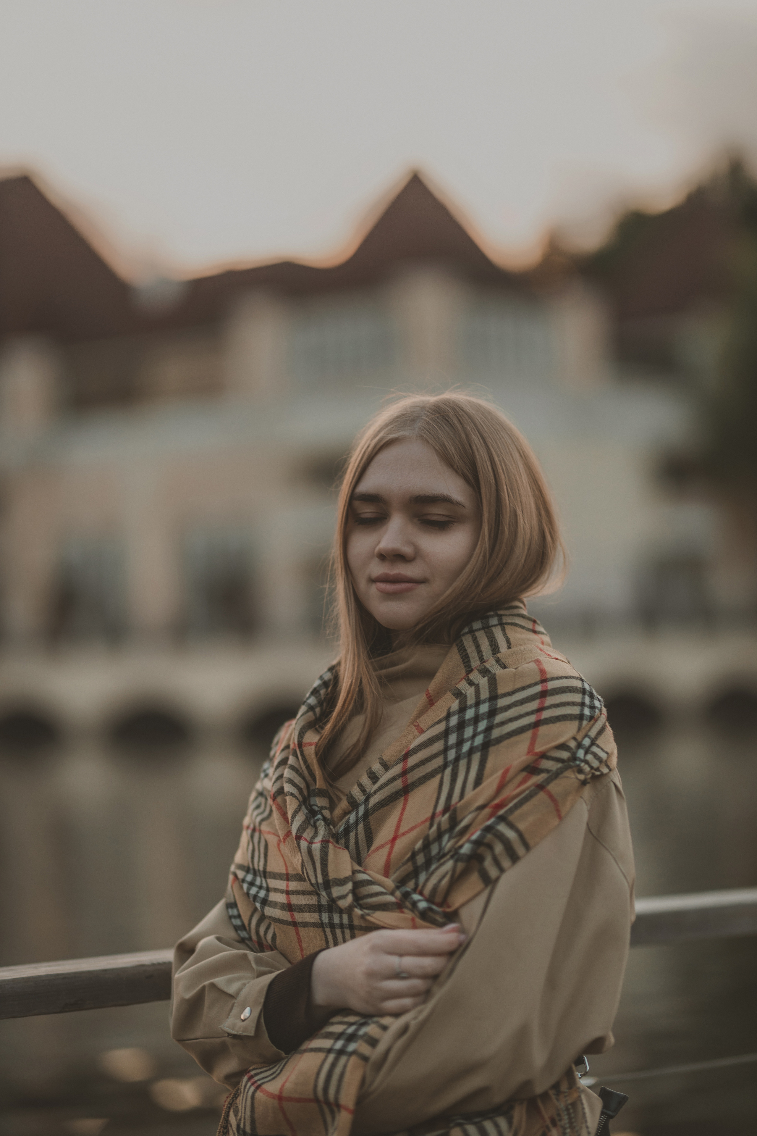 Стильный женский портрет на мосту в закатном свете, профессиональная уличная съёмка с акцентом на атмосферу