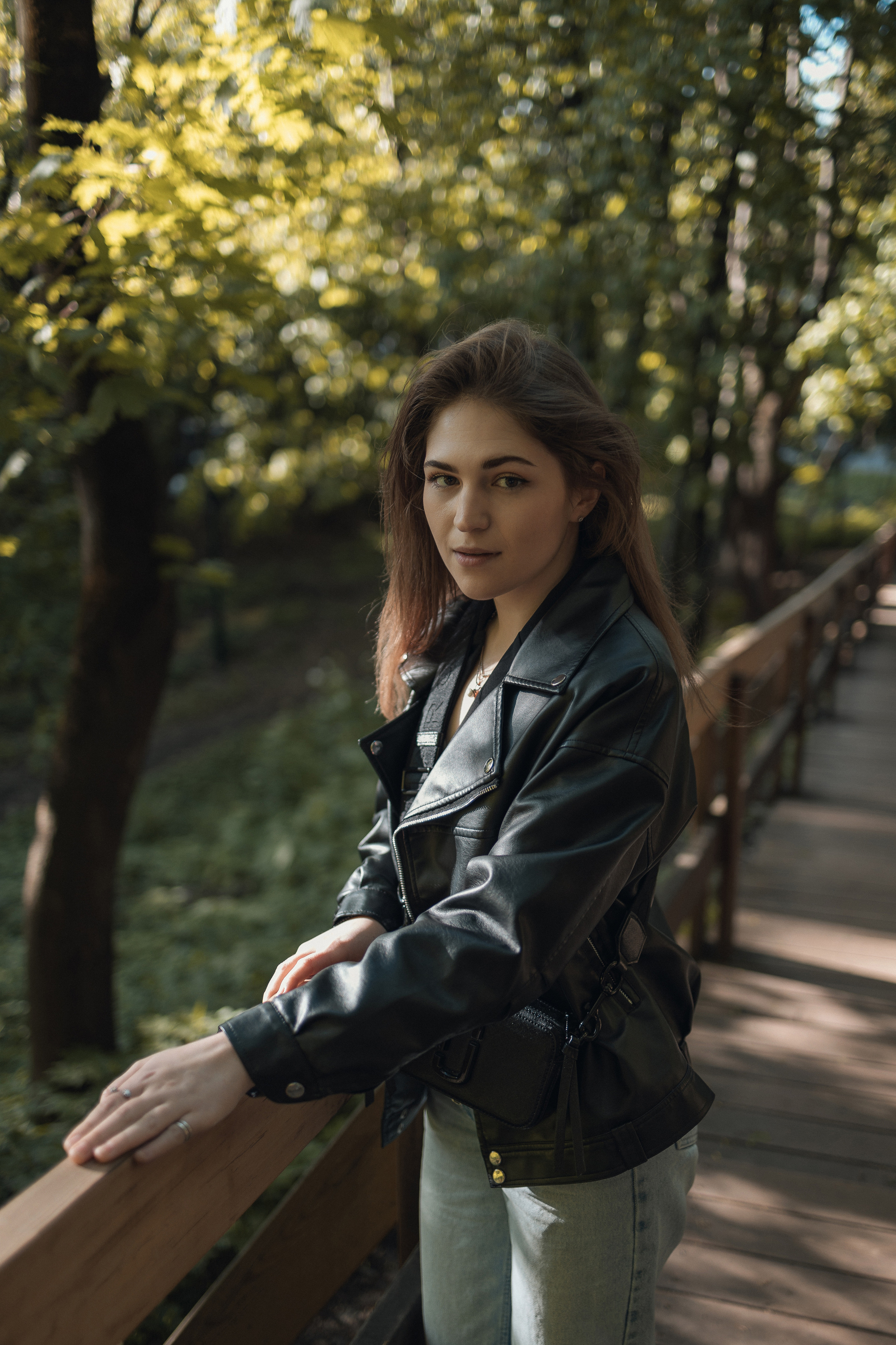 осенняя фотосессия с кожаной курткой, девушка позирует у моста