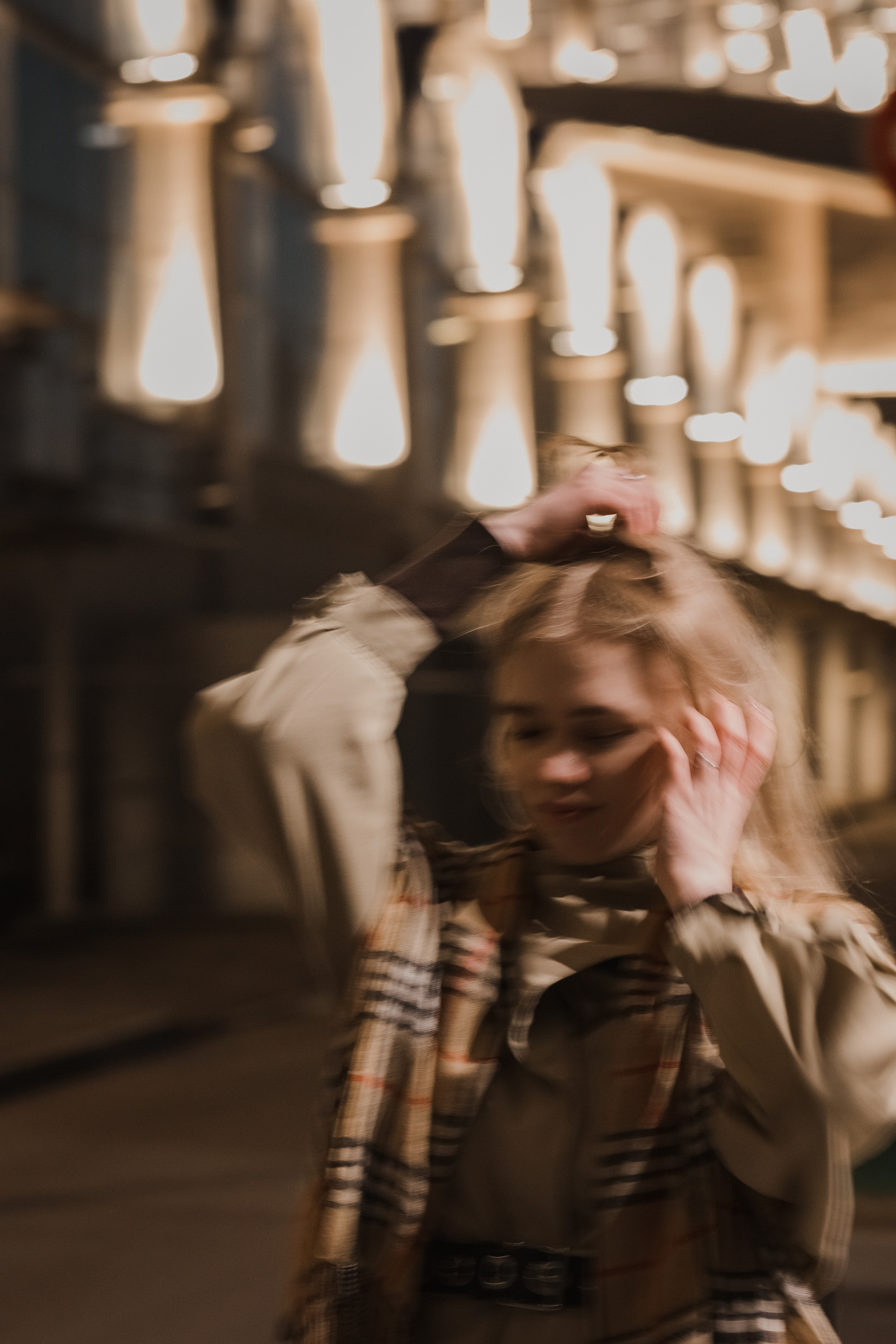 Девушка в клетчатом шарфе среди архитектуры, тёплый дневной портрет, лёгкое настроение