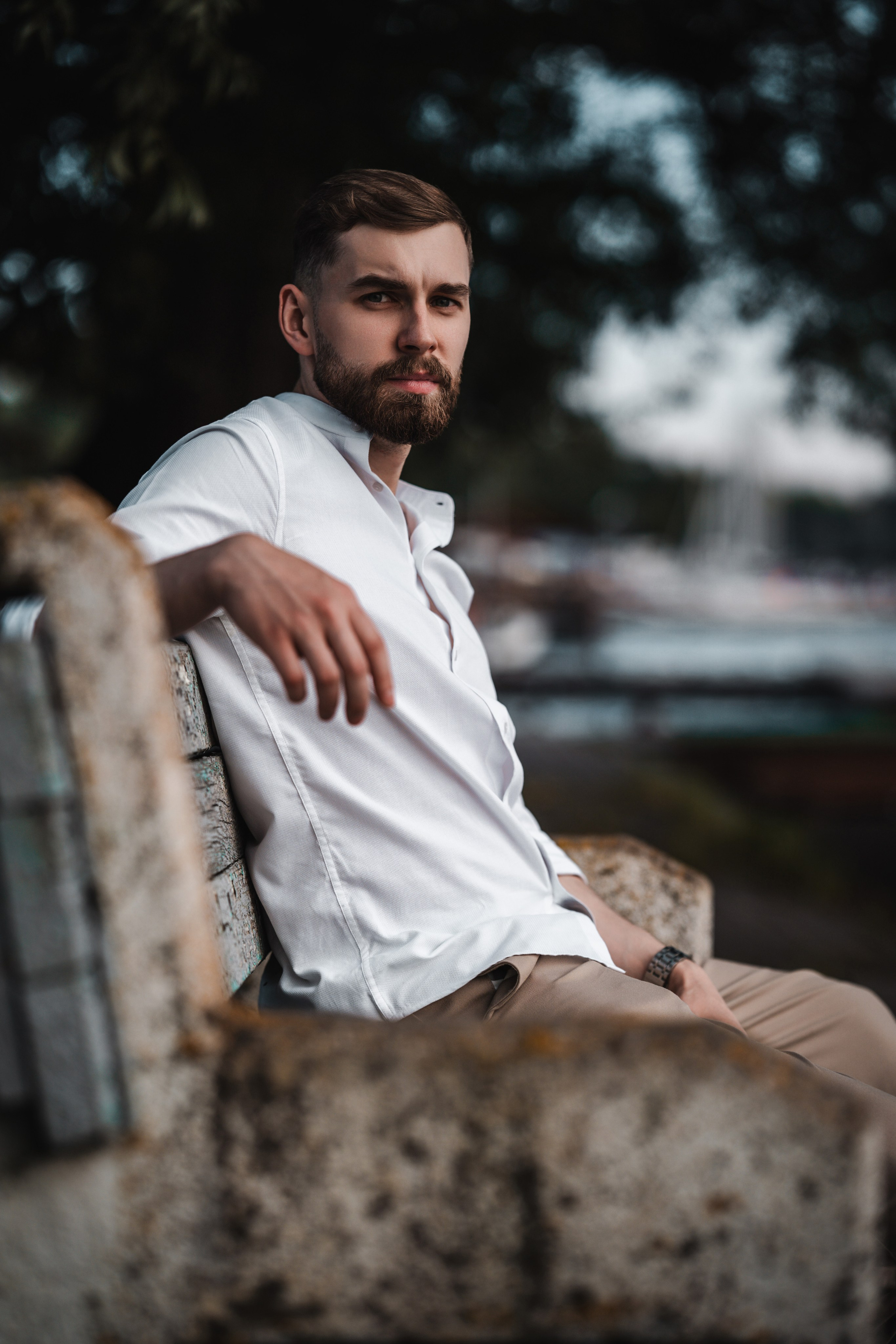 Мужской портрет в белой рубашке на каменной скамье, атмосферная фотосессия в киношном стиле