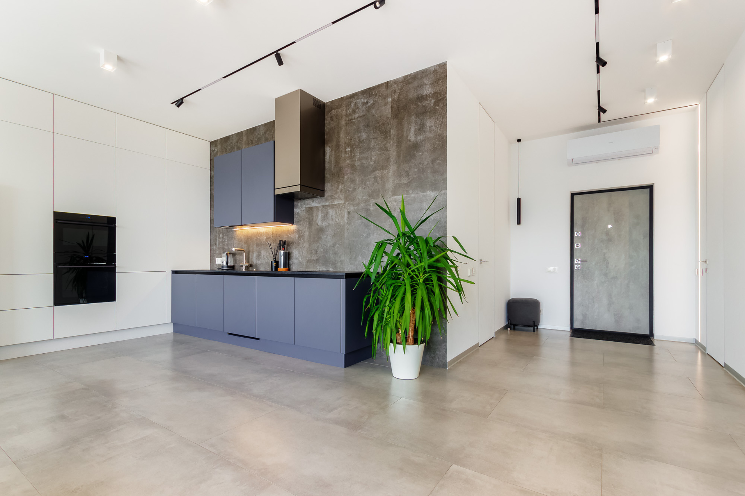 Зона прихожей и зона кухни в просторной светлой квартире-студии