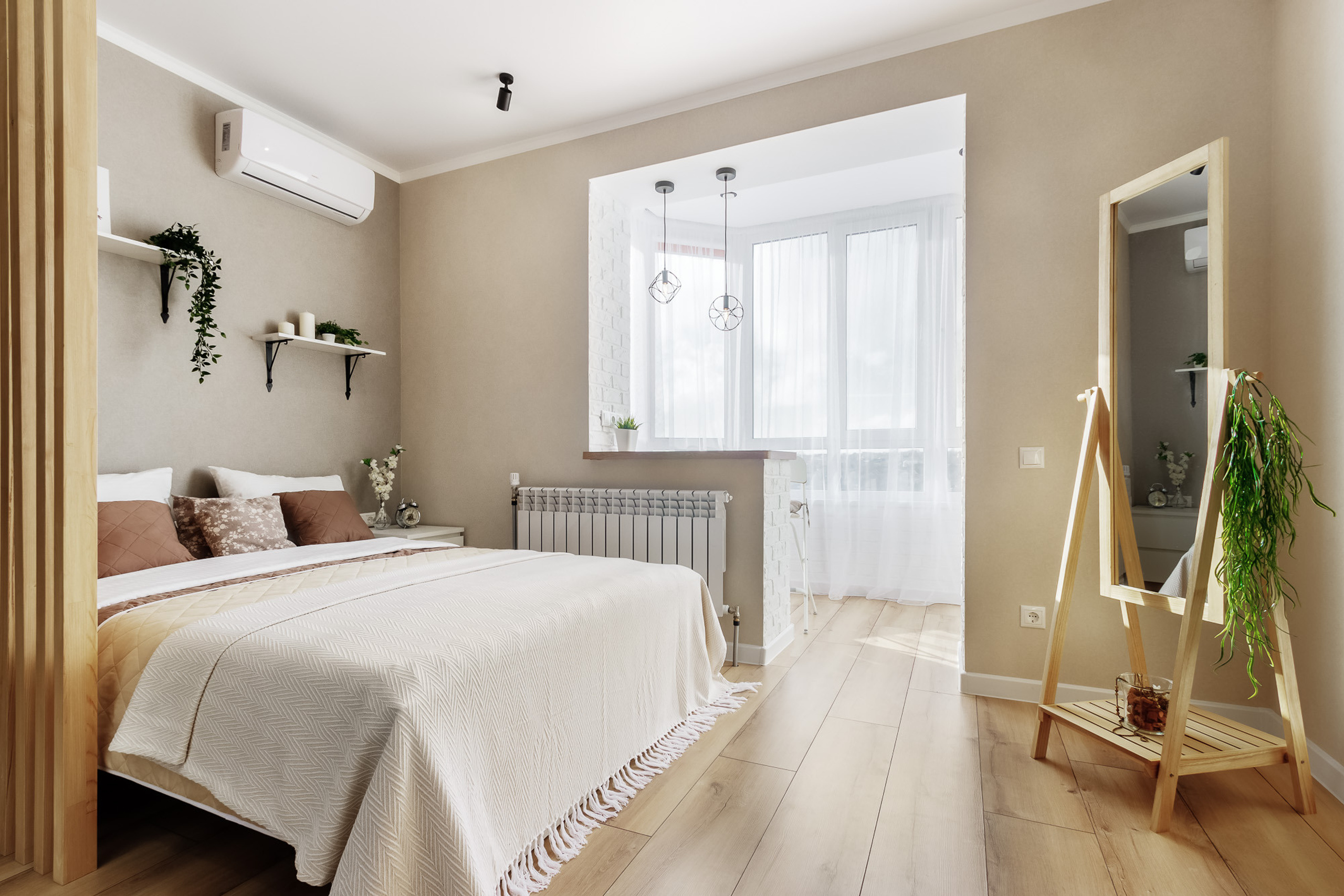 Интерьерная фотография спальни в пастельных тонах с кроватью и зеркалом