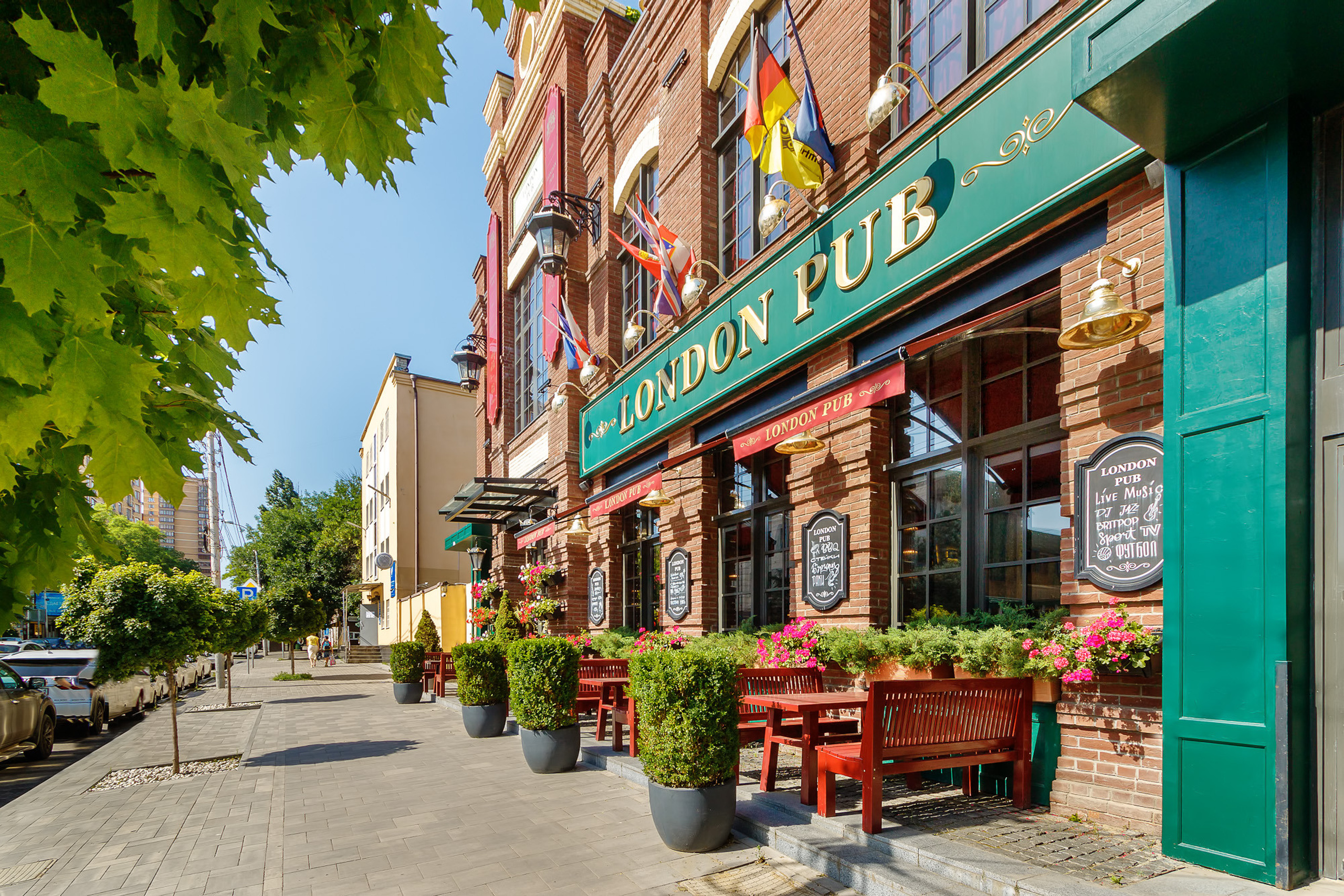 Фасад исторического здания с расположенным на первом этаже рестораном и летней террасой. Ростов-на-Дону