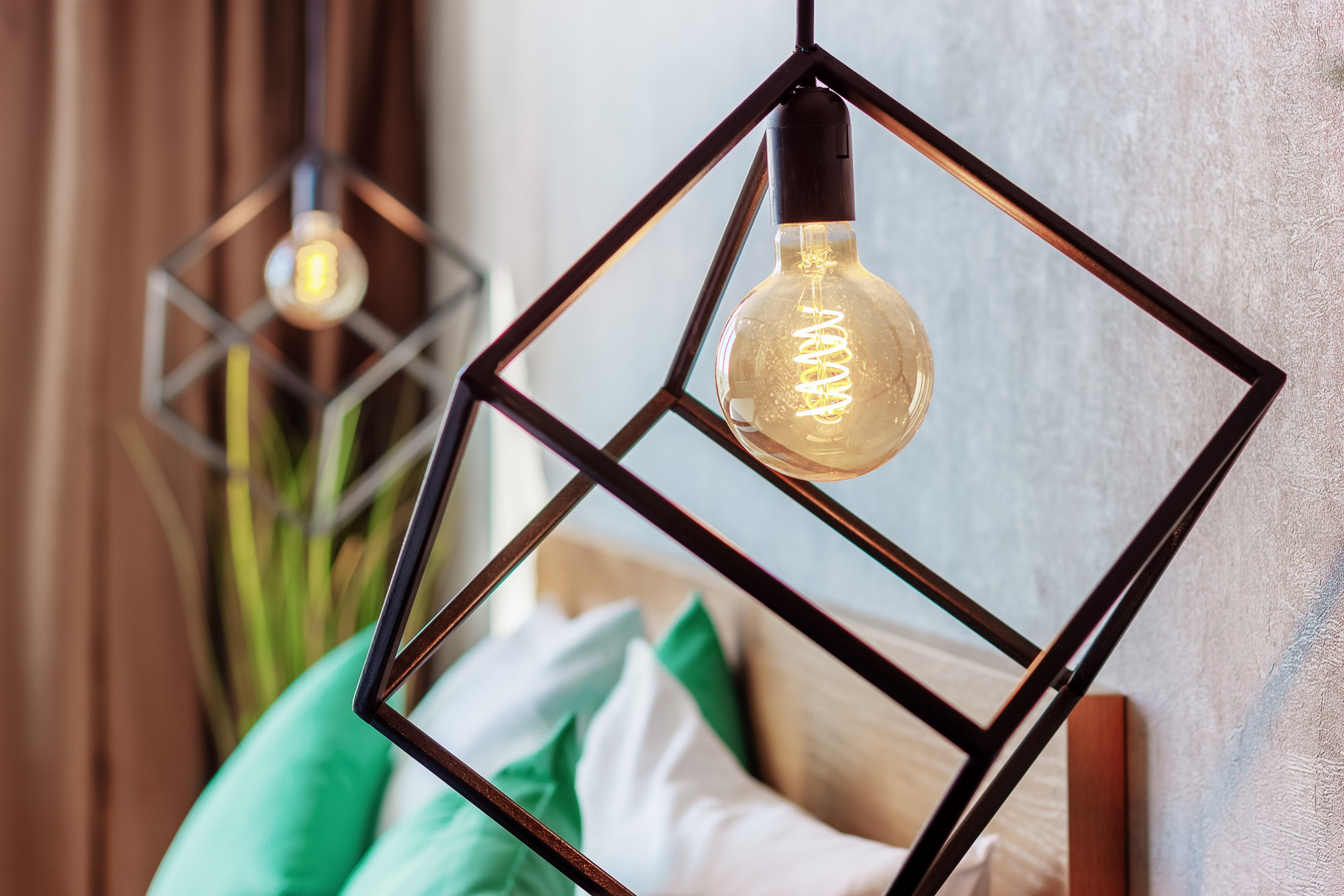 Крупный план металлических дизайнерских светильников у изголовья кровати