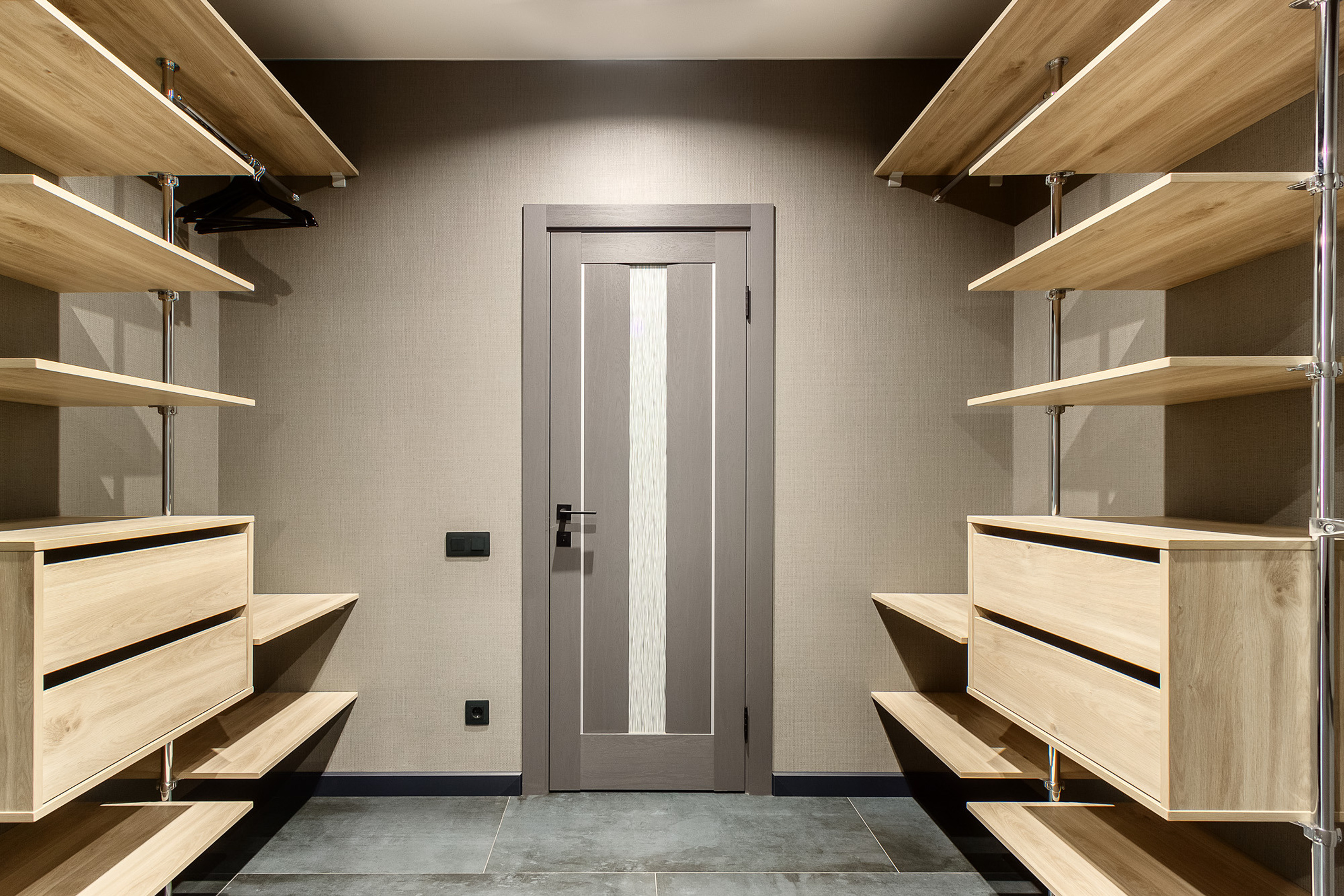 Фотография пустой гардеробной комнаты с деревянными полками и коричневыми стенами