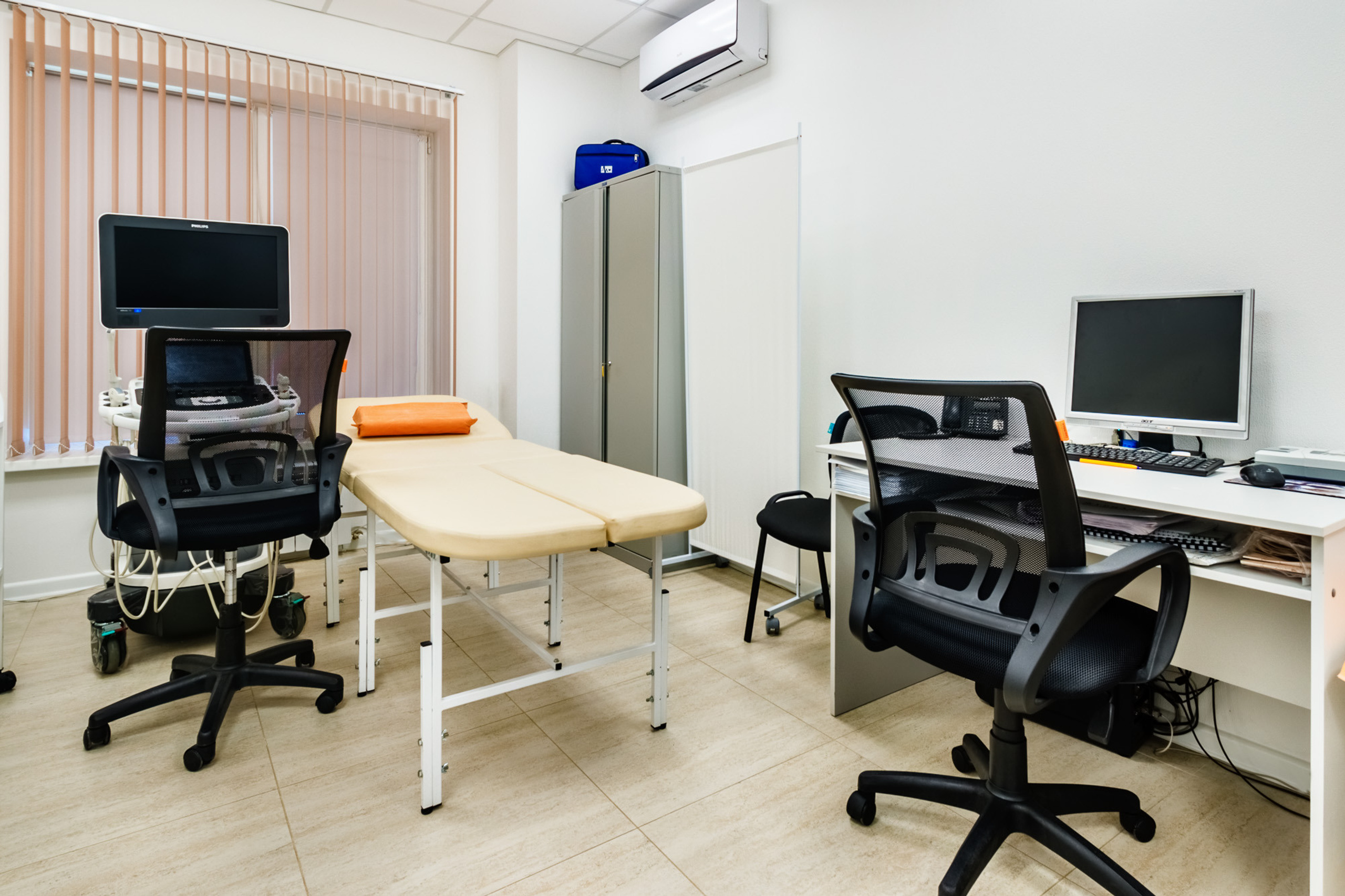 Медицинский кабинет в современной клинике, оснащённый компьютерной техникой