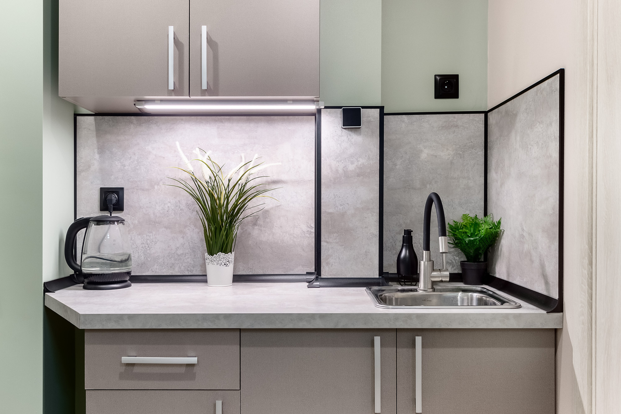 Небольшая кухонная зона с мойкой в маленькой квартире-студии