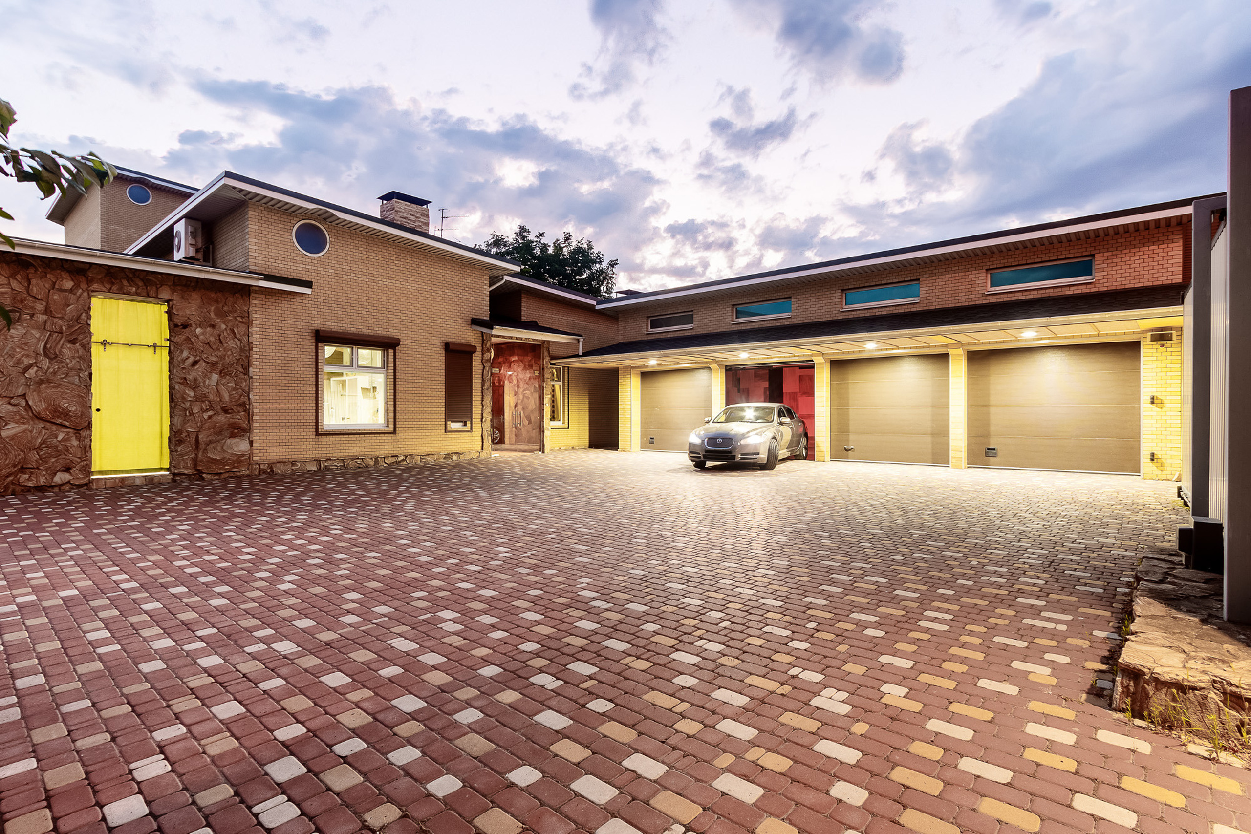 Двор частного дома с гаражом в вечернее время