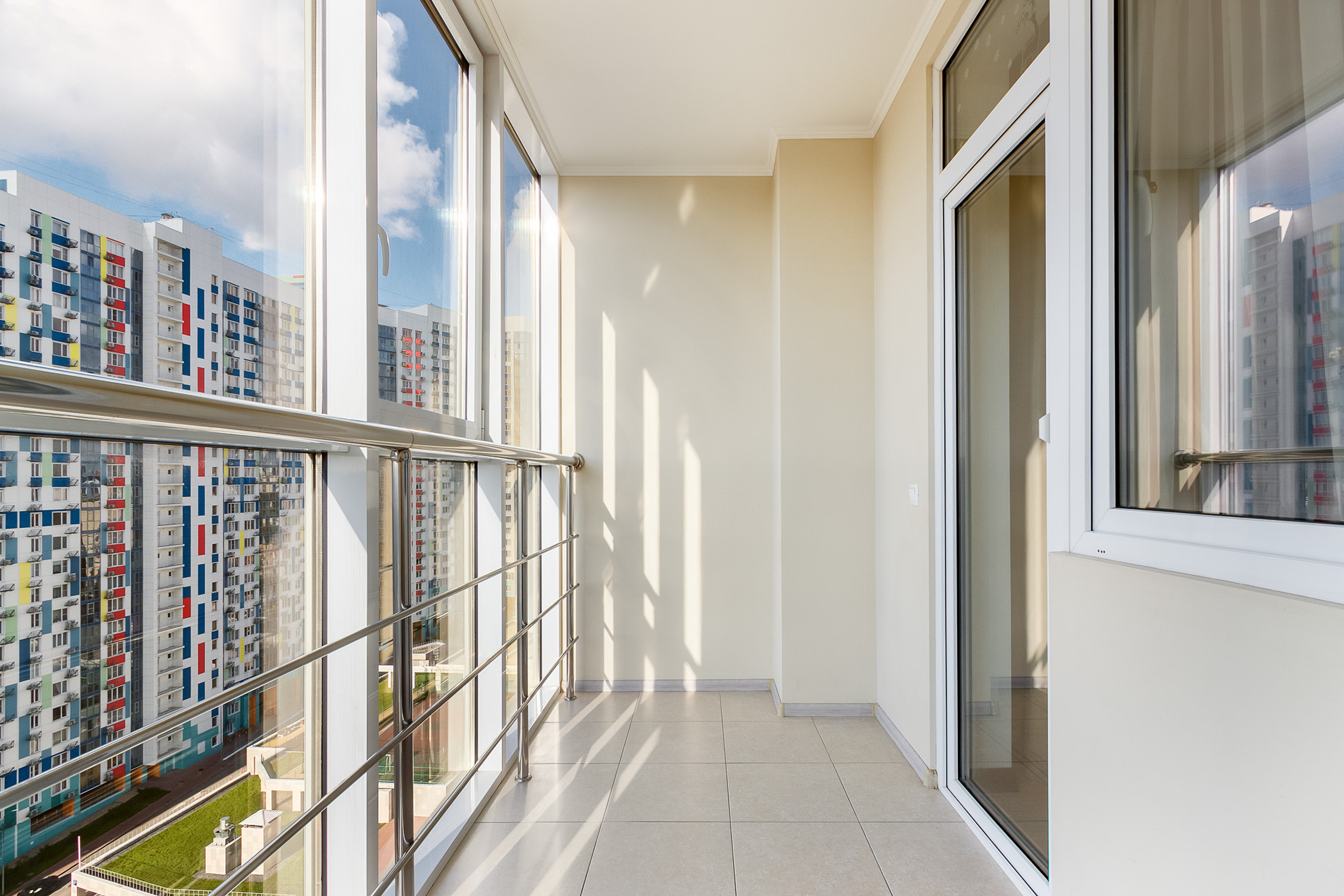 Фотография большой солнечной лоджии с панорамным остеклением в современном жилом комплексе в Ростове