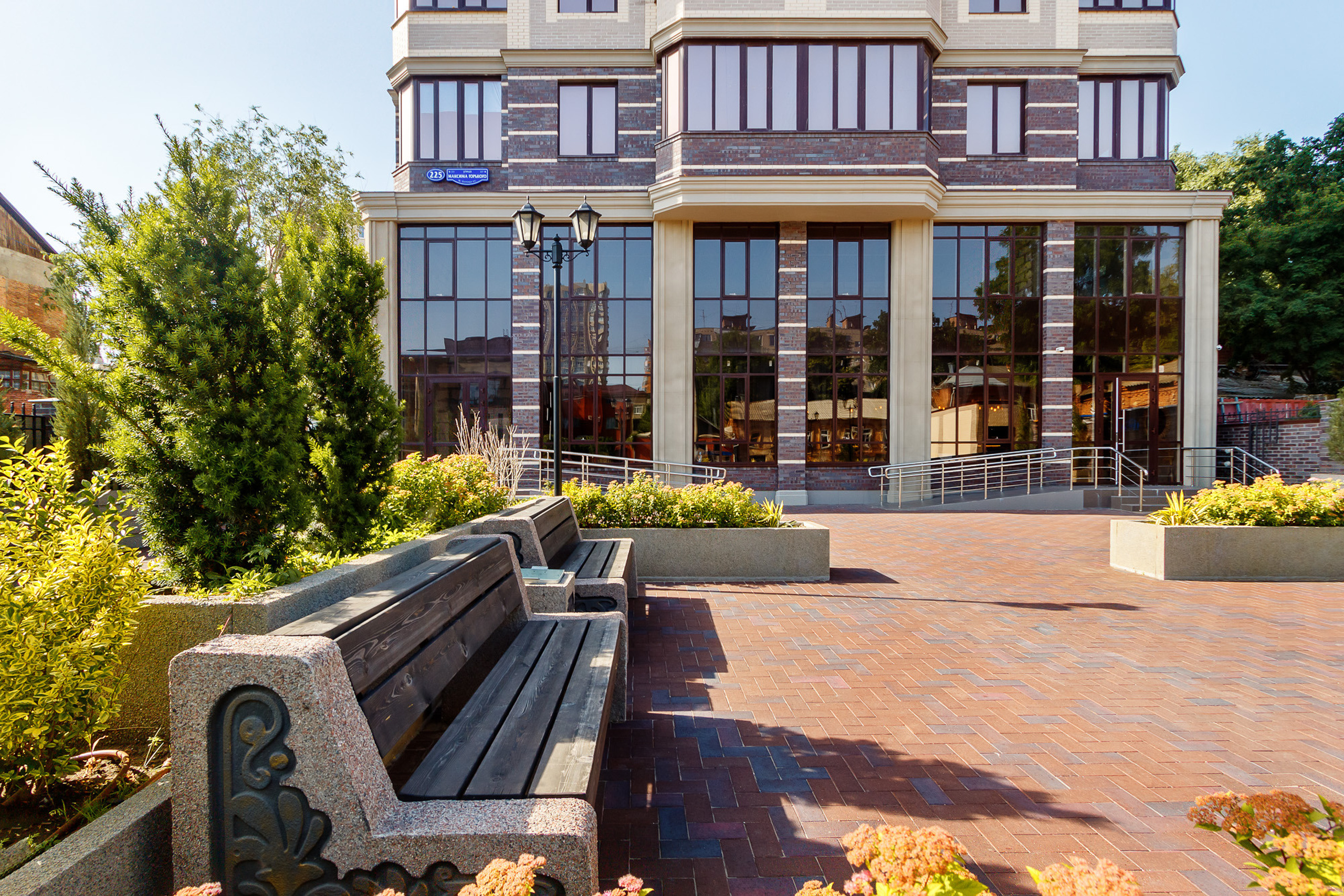 Двор жилого многоэтажного дома с бетонными лавочками