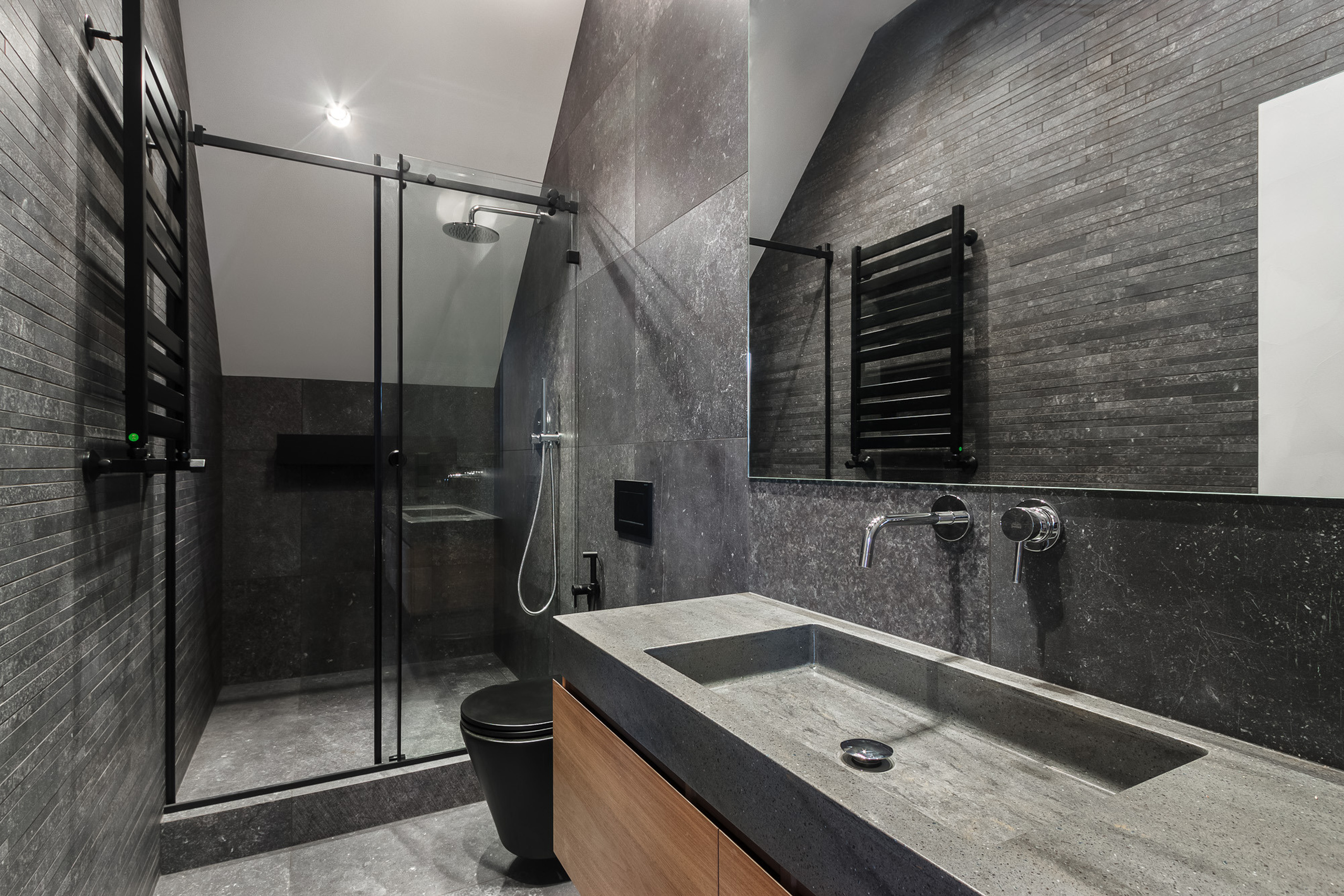 Тёмный дизайн ванной комнаты с прямоугольным умывальником и душем за стеклянной перегородкой