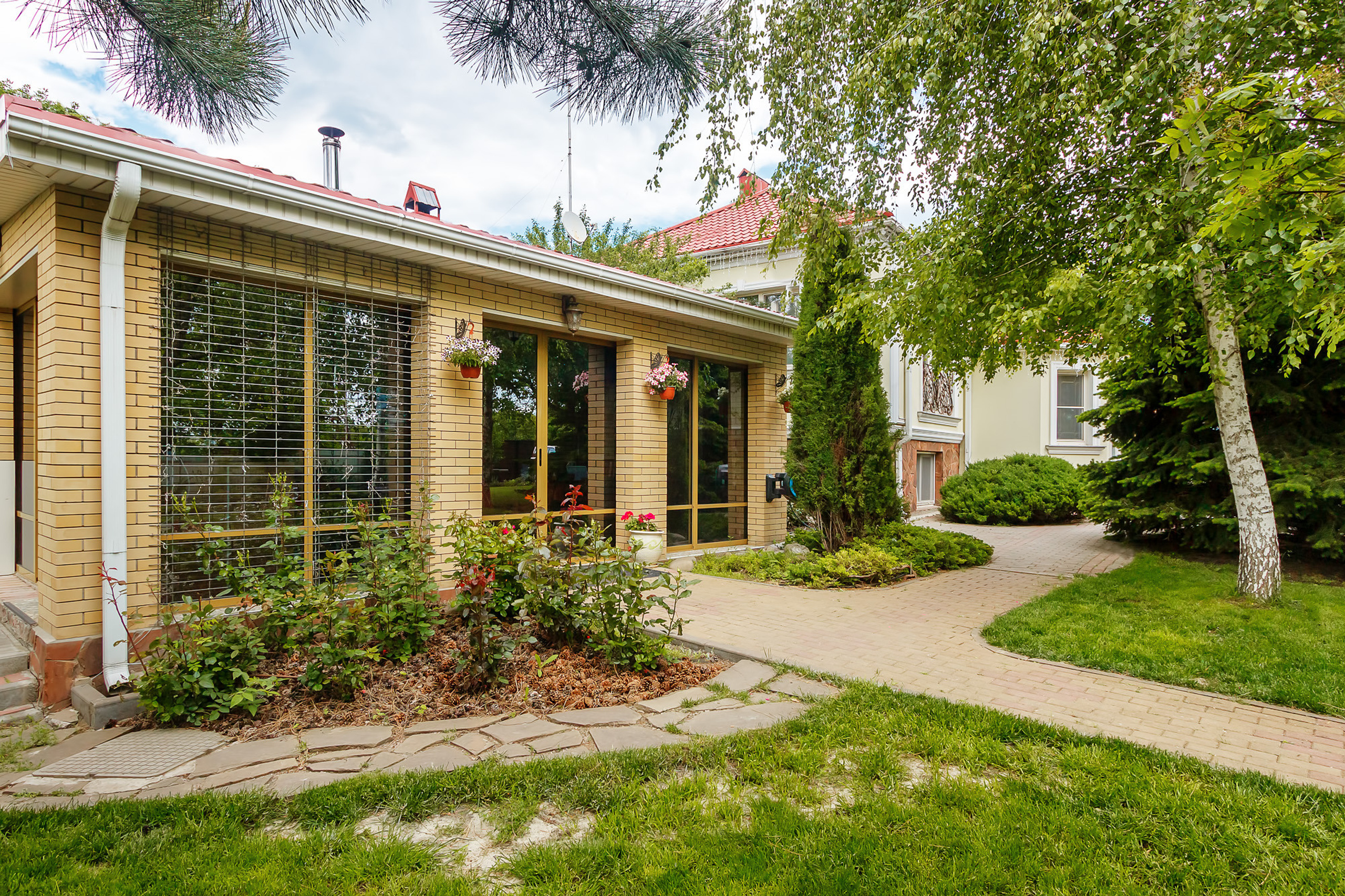 Двор загородного дома с ландшафтным дизайном и хозяйственными постройками