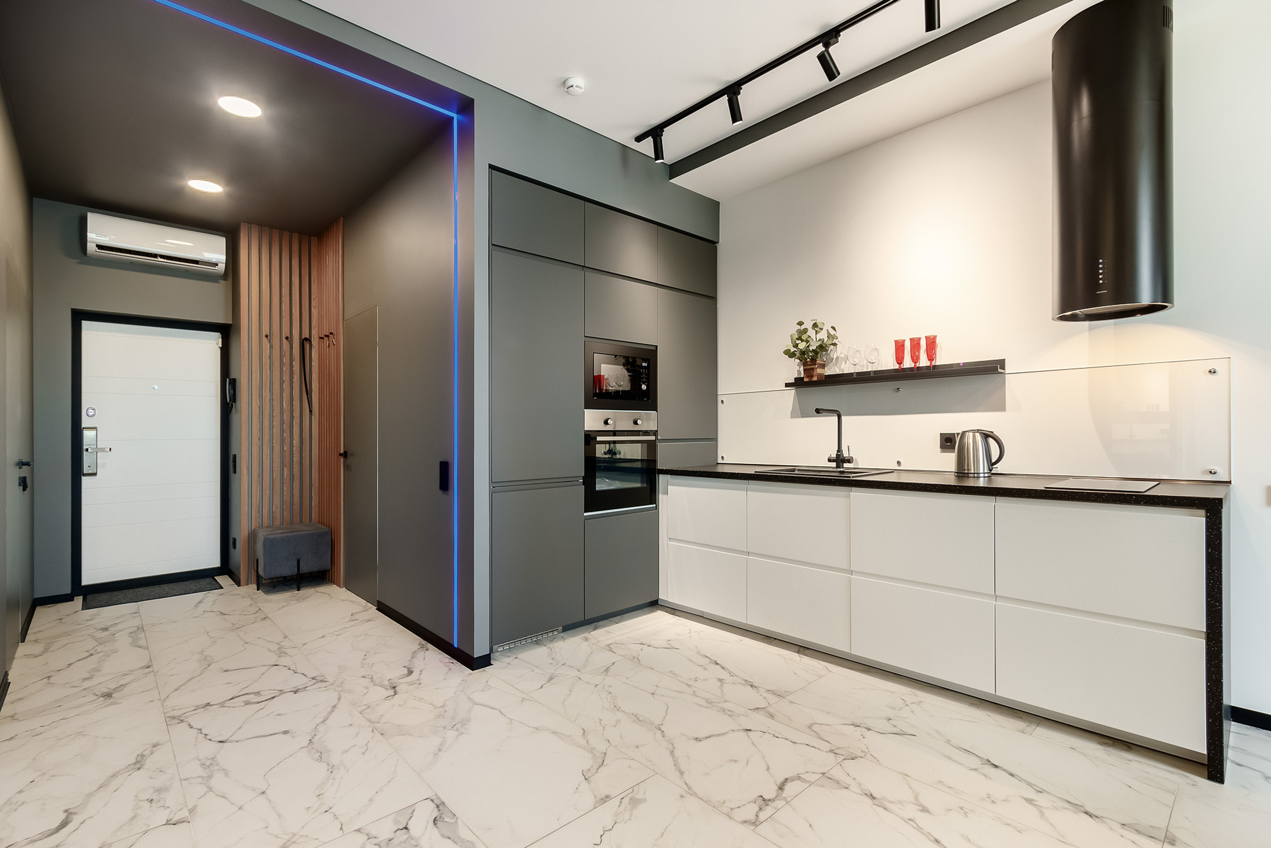 Зоны прихожей и кухни в большой квартире-студии в графитовом цвете