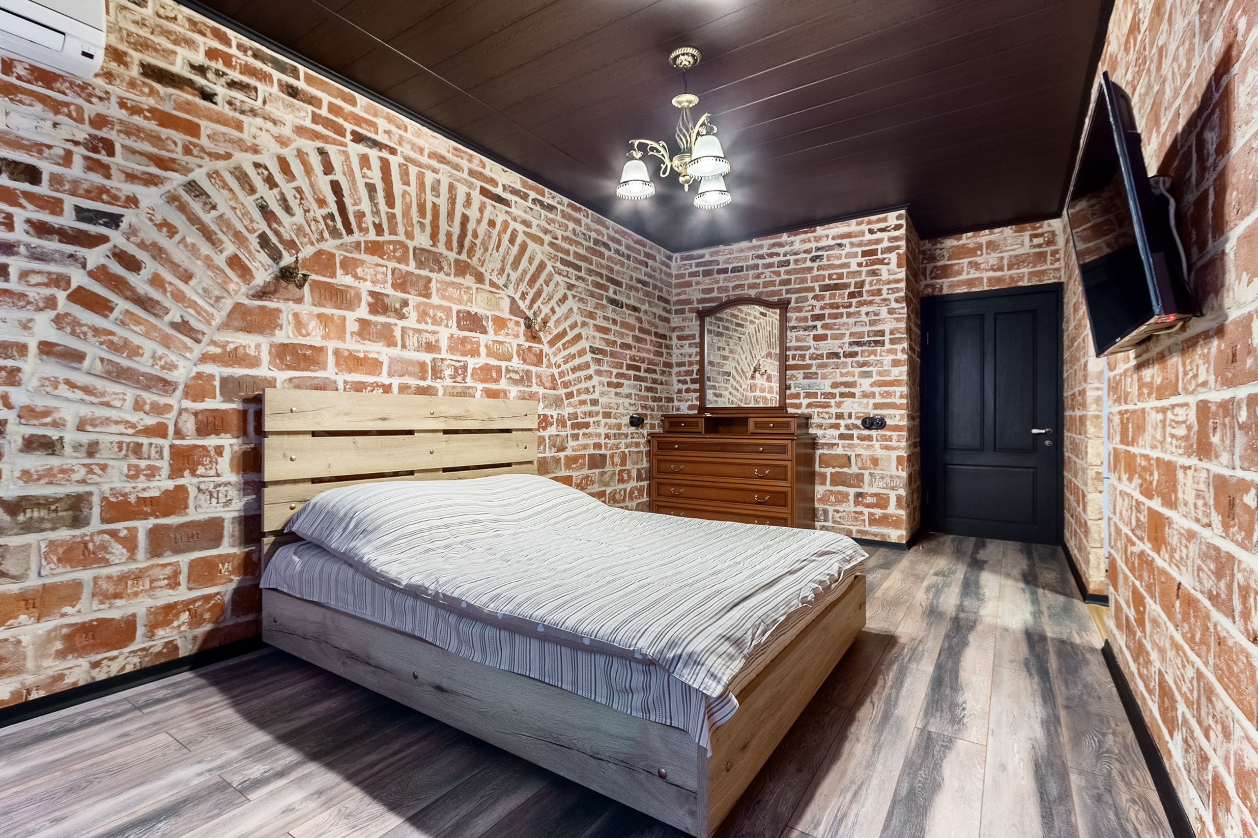 Минималистичный дизайн интерьера спальни, отделанной старым кирпичом