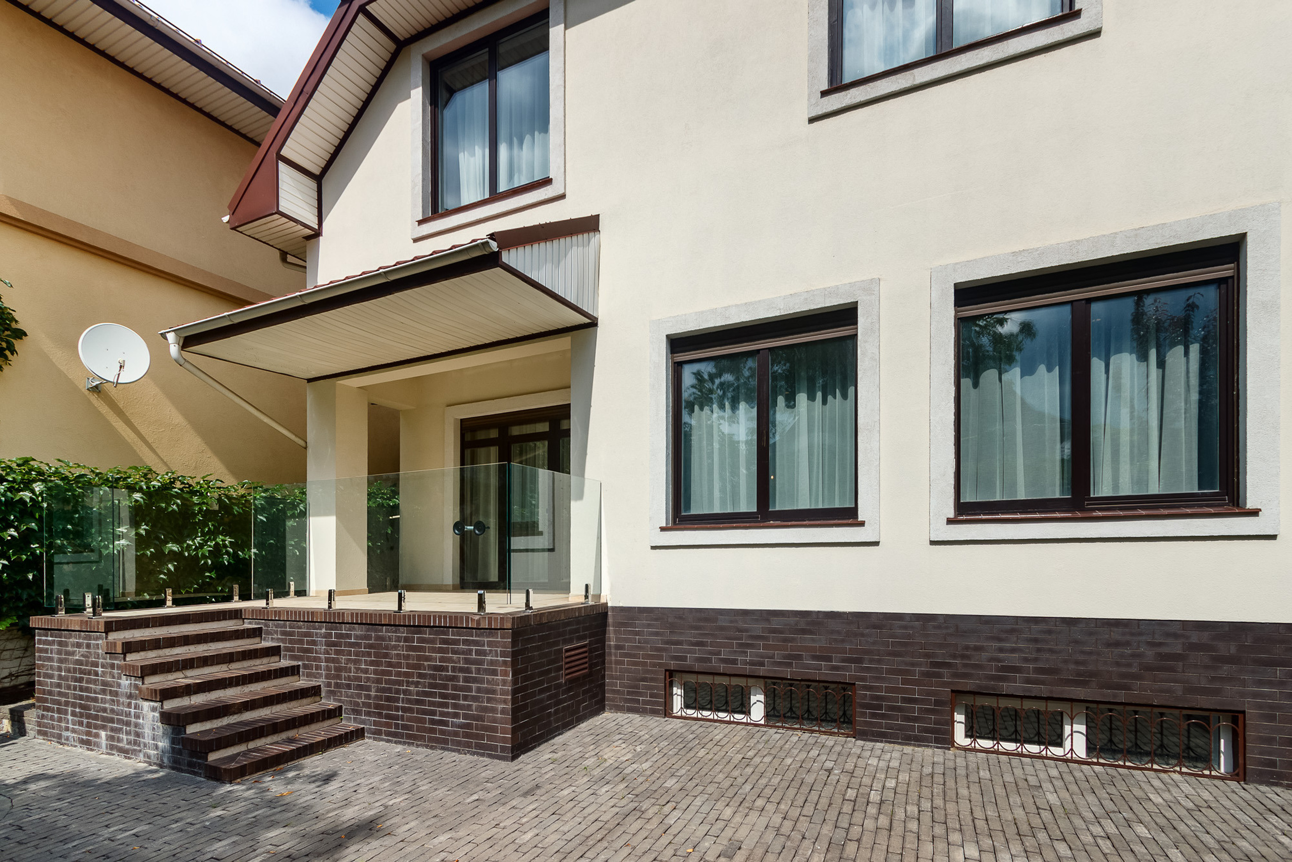 Вход в двухэтажный загородный дом со стороны заднего двора