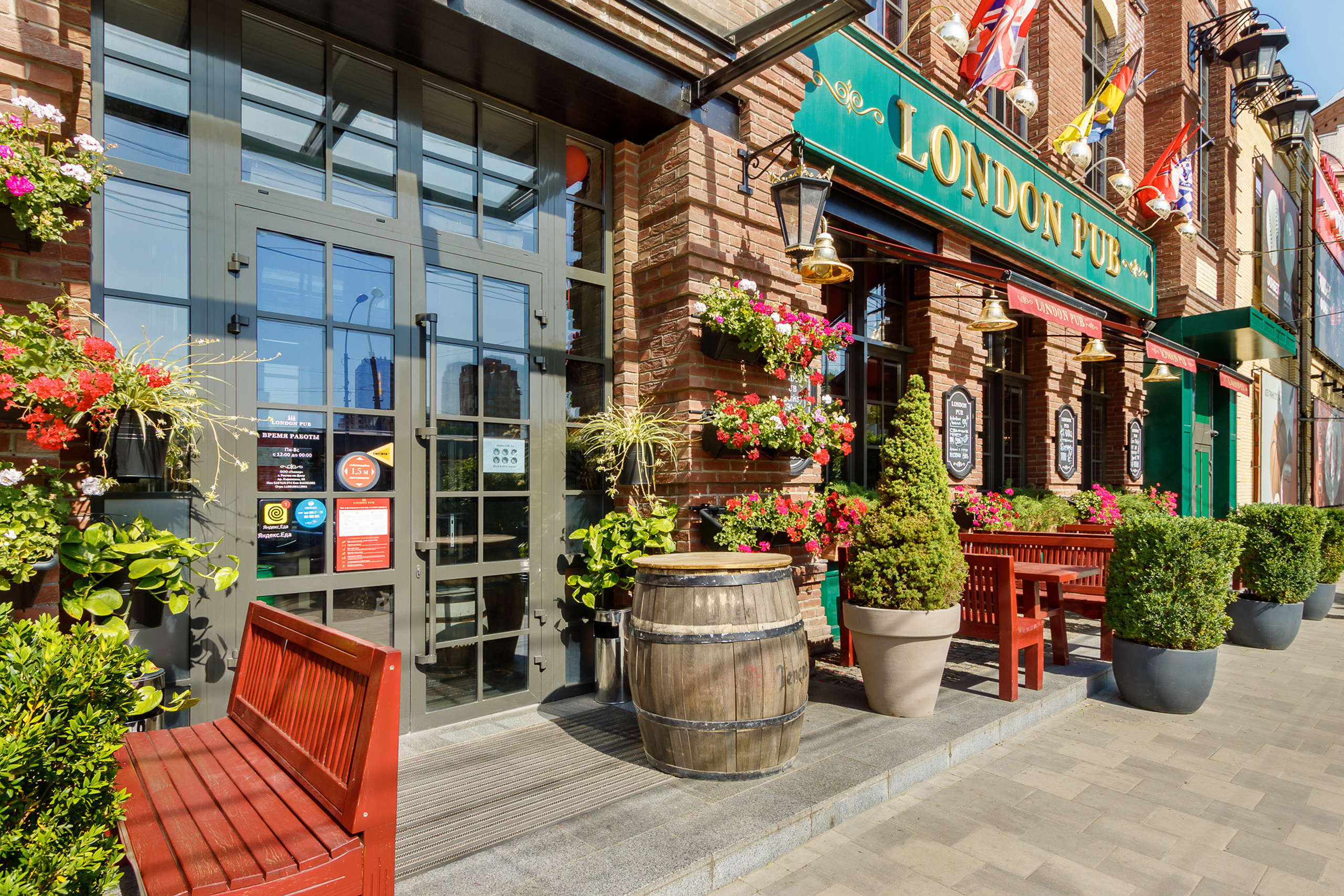 Вход в ресторан в Ростове со столиками у стены и большим количеством цветов