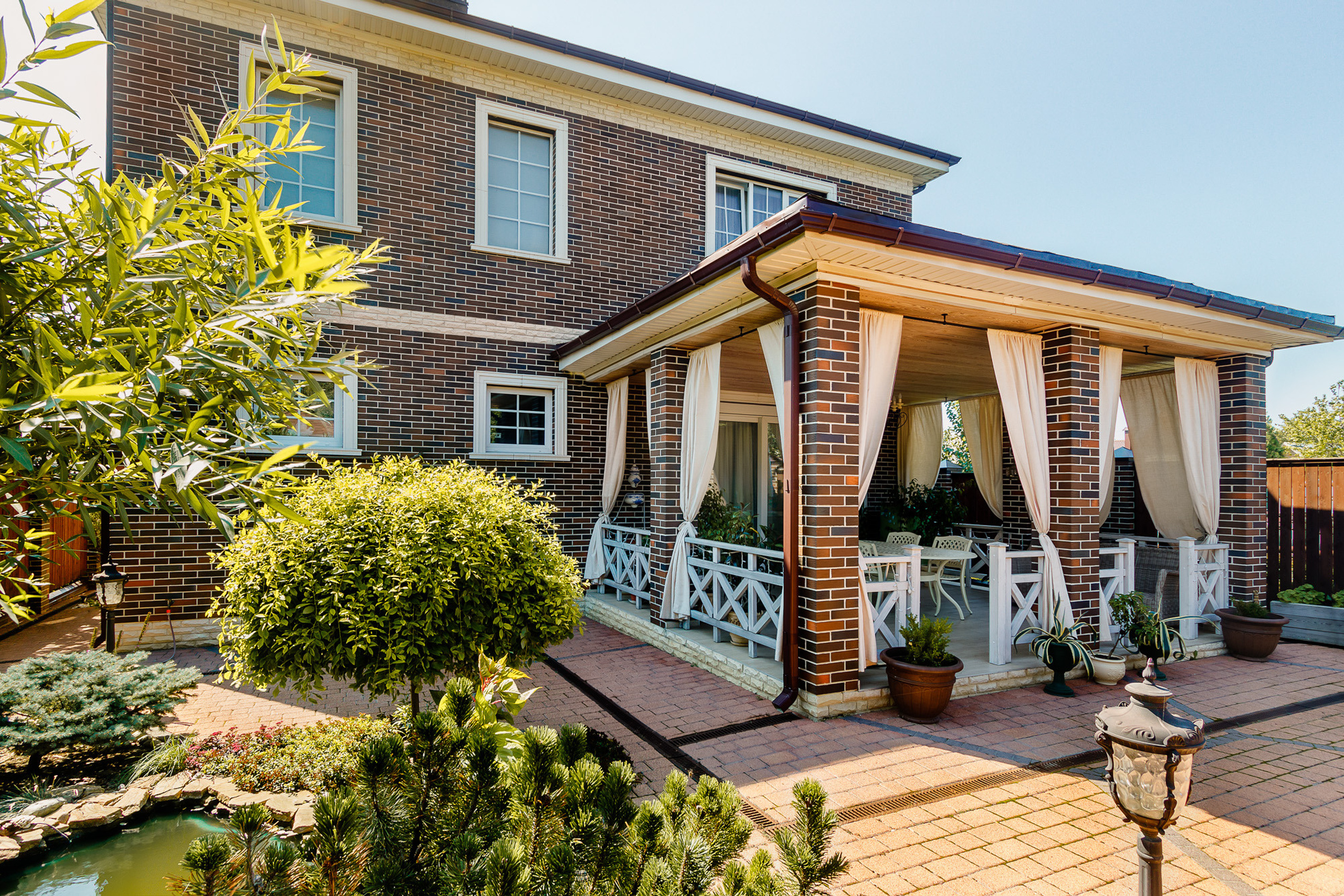 Веранда во внутреннем дворе кирпичного загородного дома