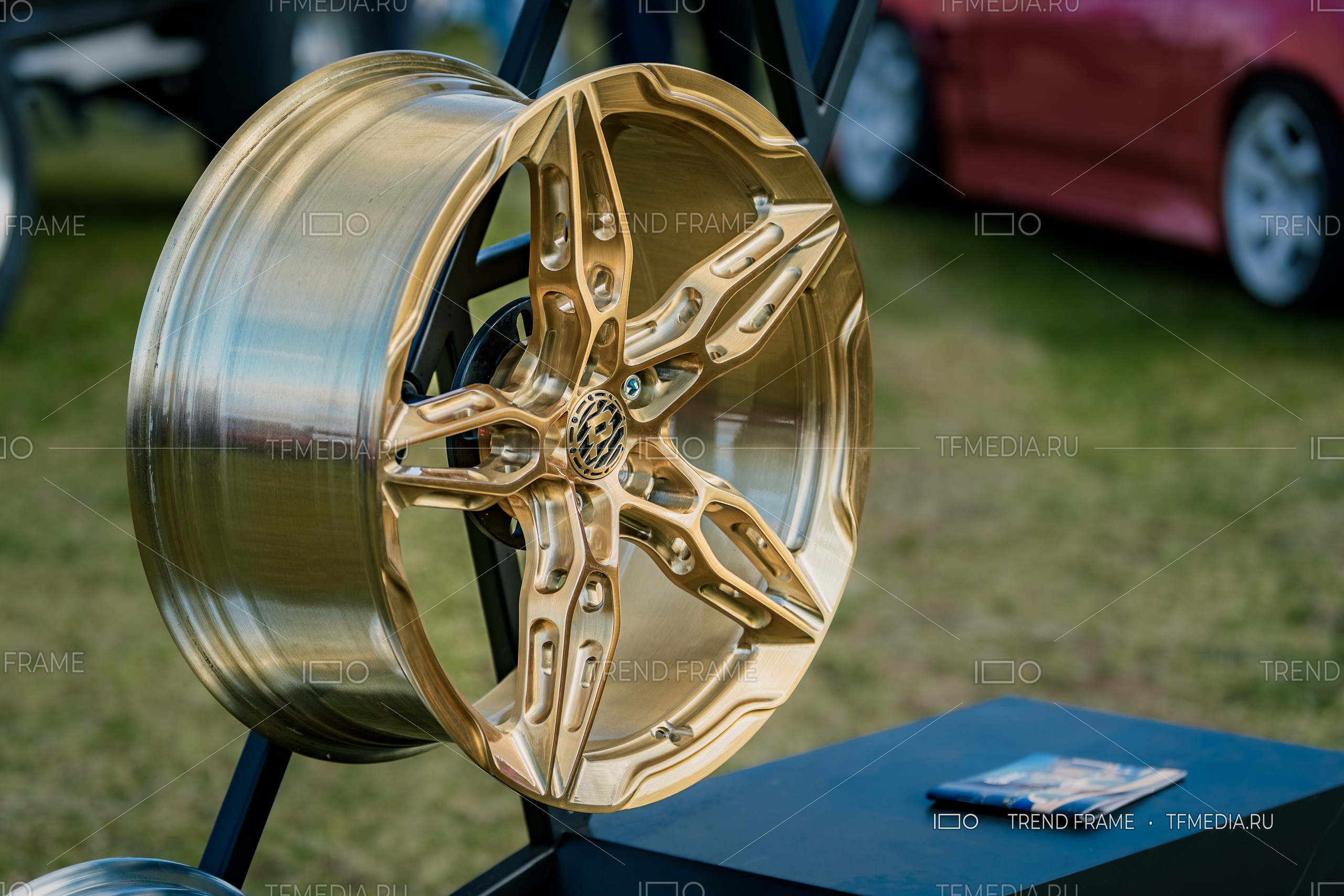 PowerWheels — кованый диск в золотистом покрытии, предметная съёмка на выставке, боковой ракурс, Москва