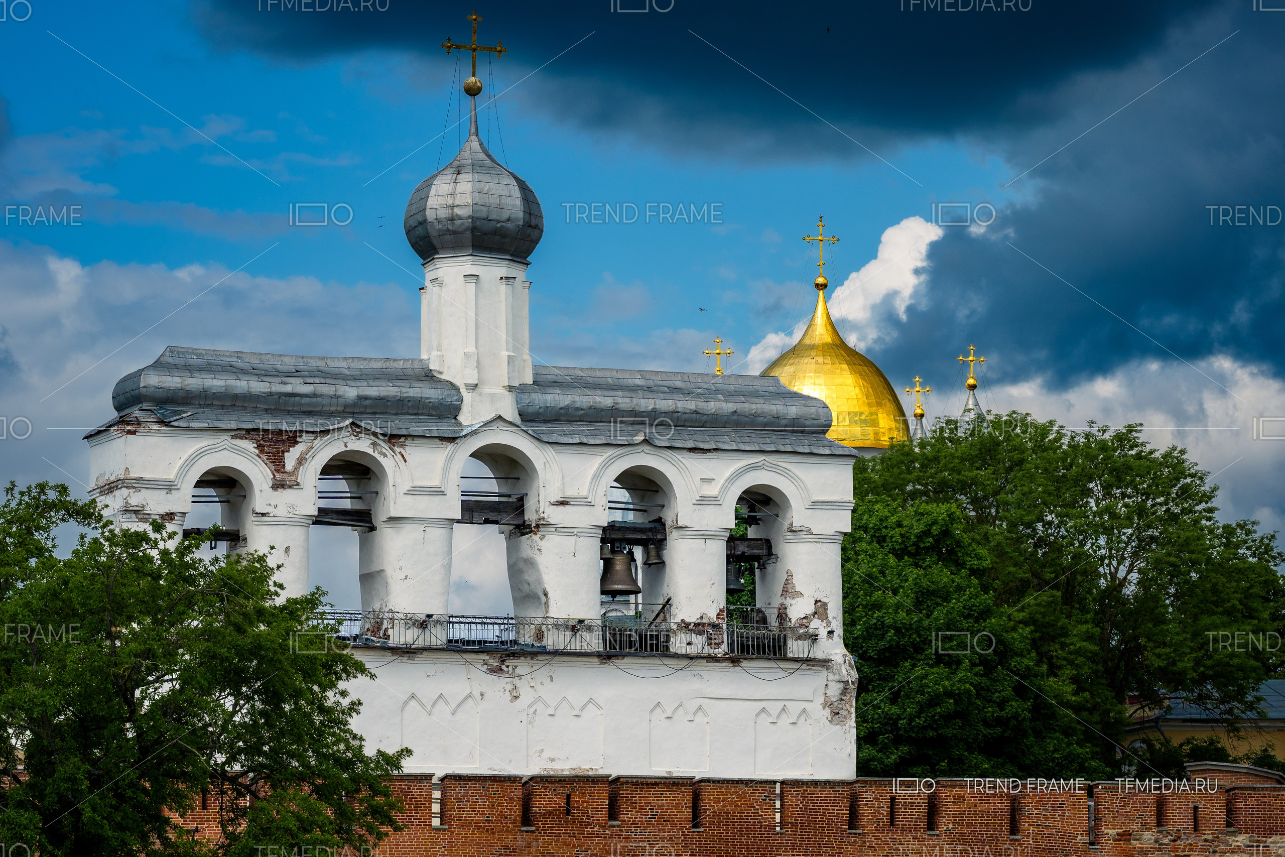 Софийская звонница и Золотой купол Софийского собора Великий Новгород фото TrendFrame, кремлёвская стена и крест на фоне облаков