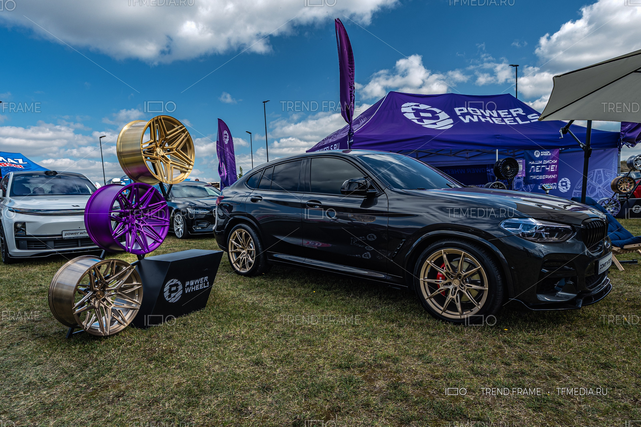 PowerWheels — стенд с коваными дисками в трёх цветах (золотистый, фиолетовый, бронзовый), выставка Москва