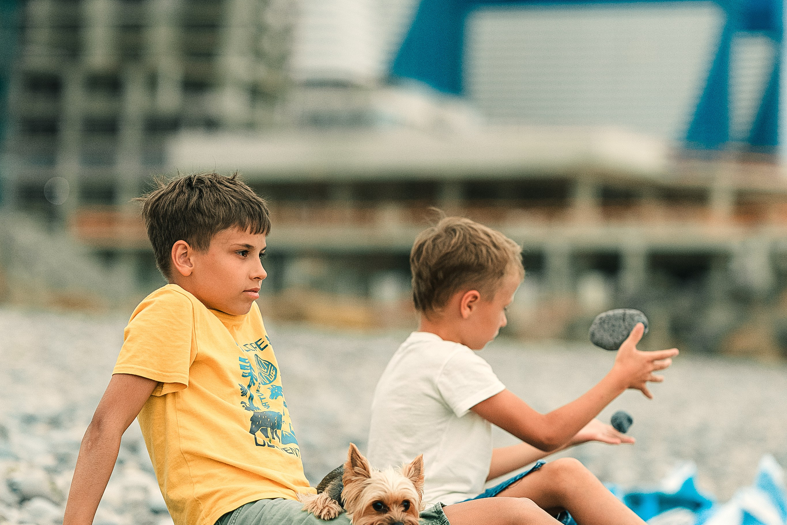 Дети сидят на пляже в Батуми и смотрят на море