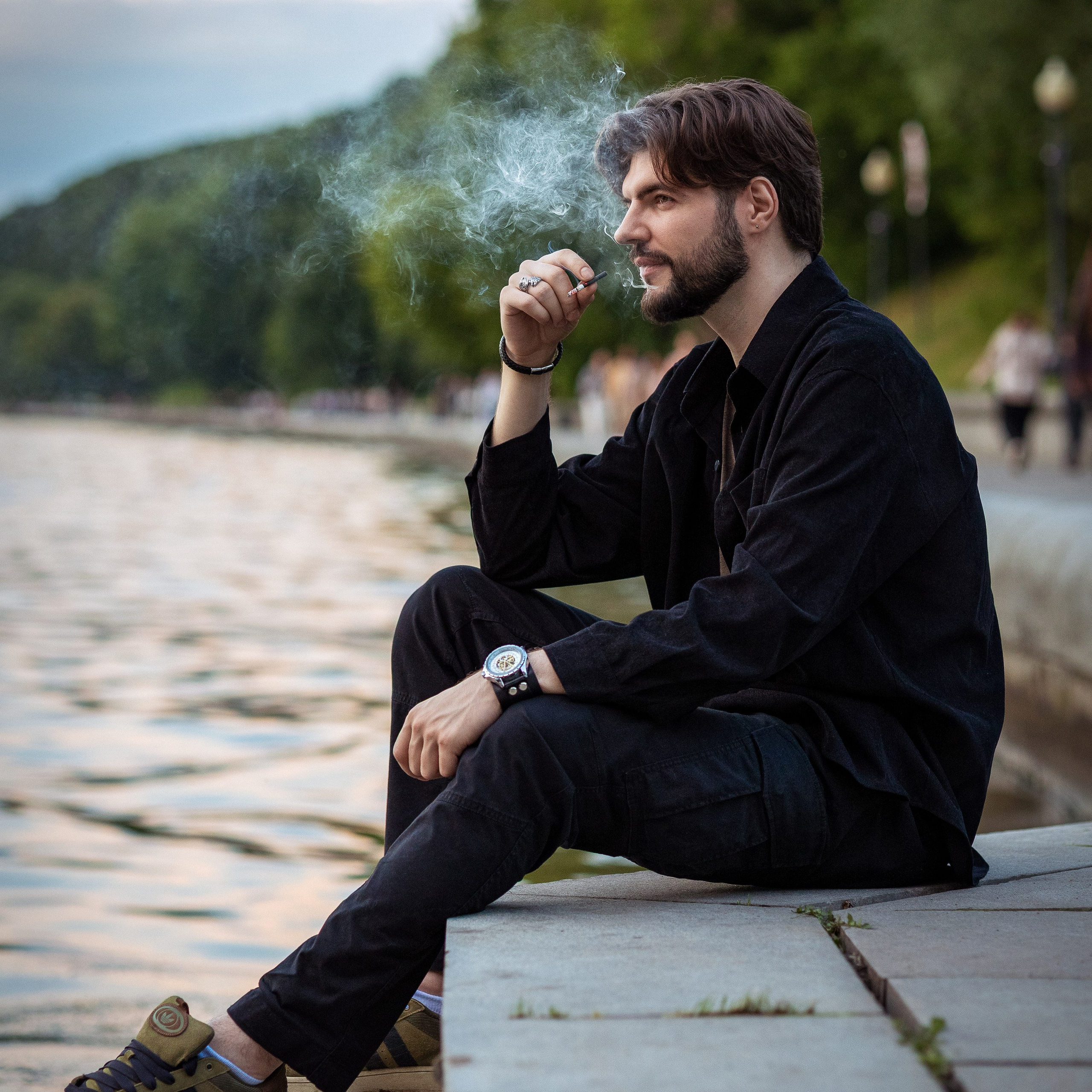 Уличная мужская съёмка в парке, зелень на заднем плане
