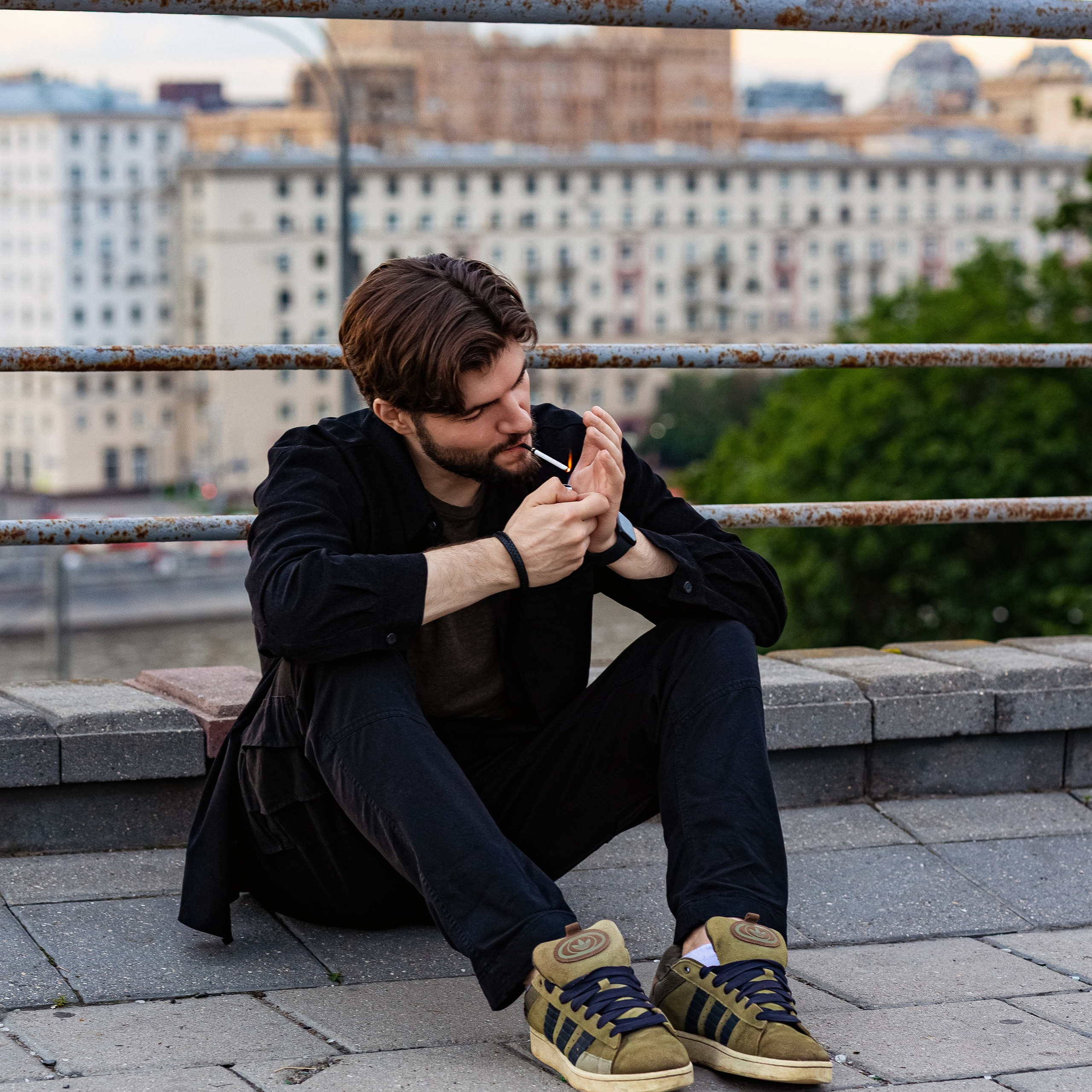 Мужская фотосессия на набережной в Москве — герой сидит у реки