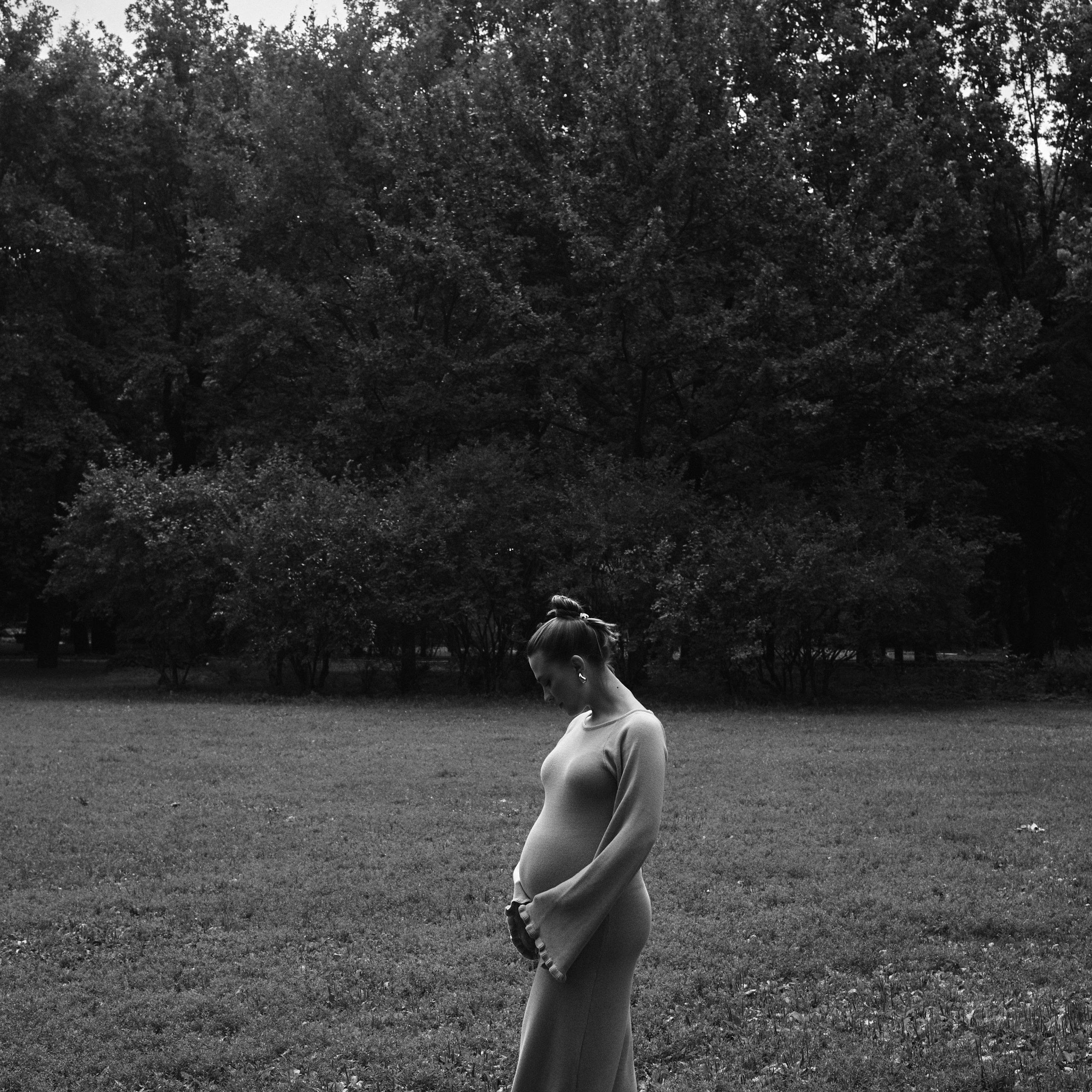 фотосессия беременной девушки в парке. черно-белое фото беременности на природе