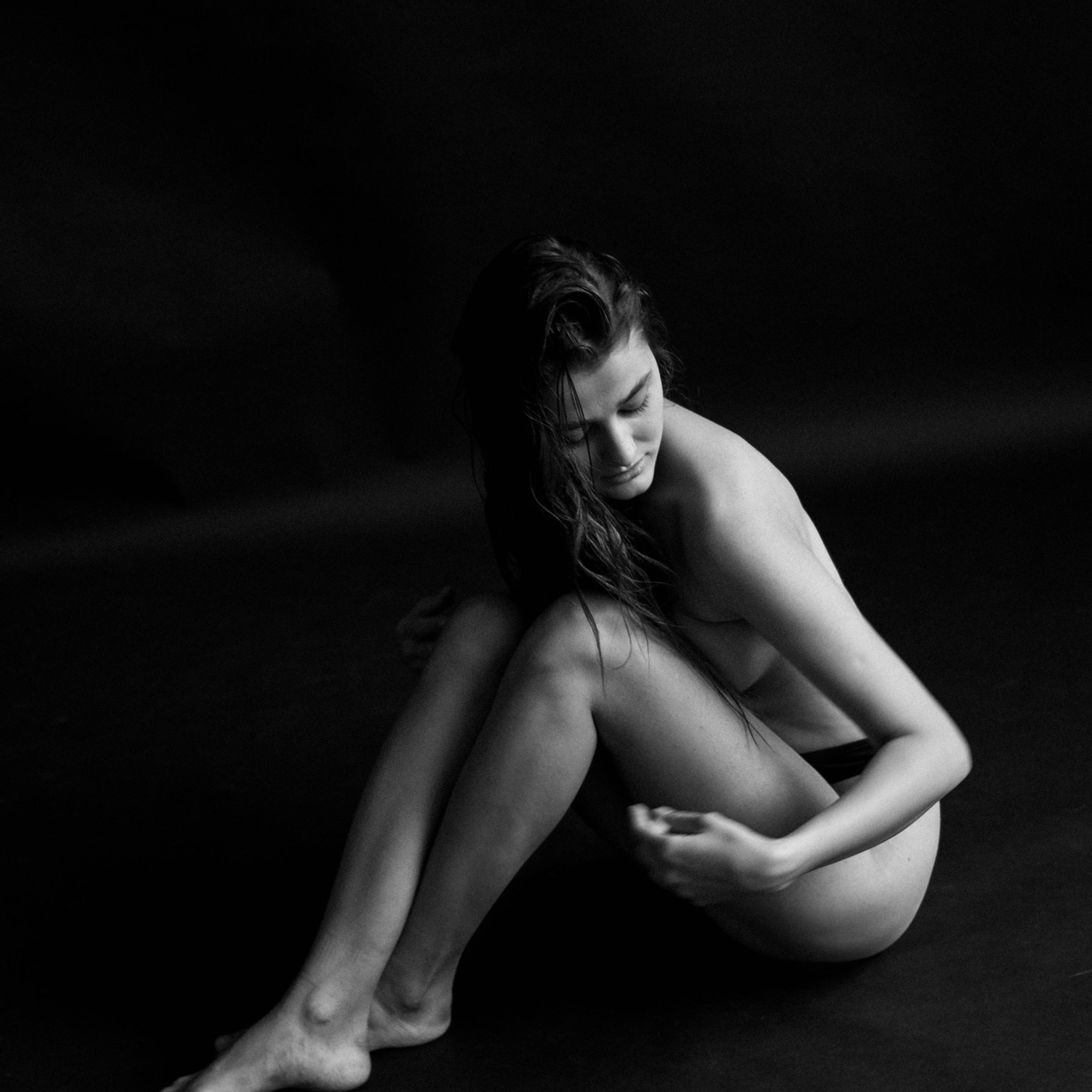 черно-белая фотосессия девушки на черном фоне. обнаженная девушка на черном фоне