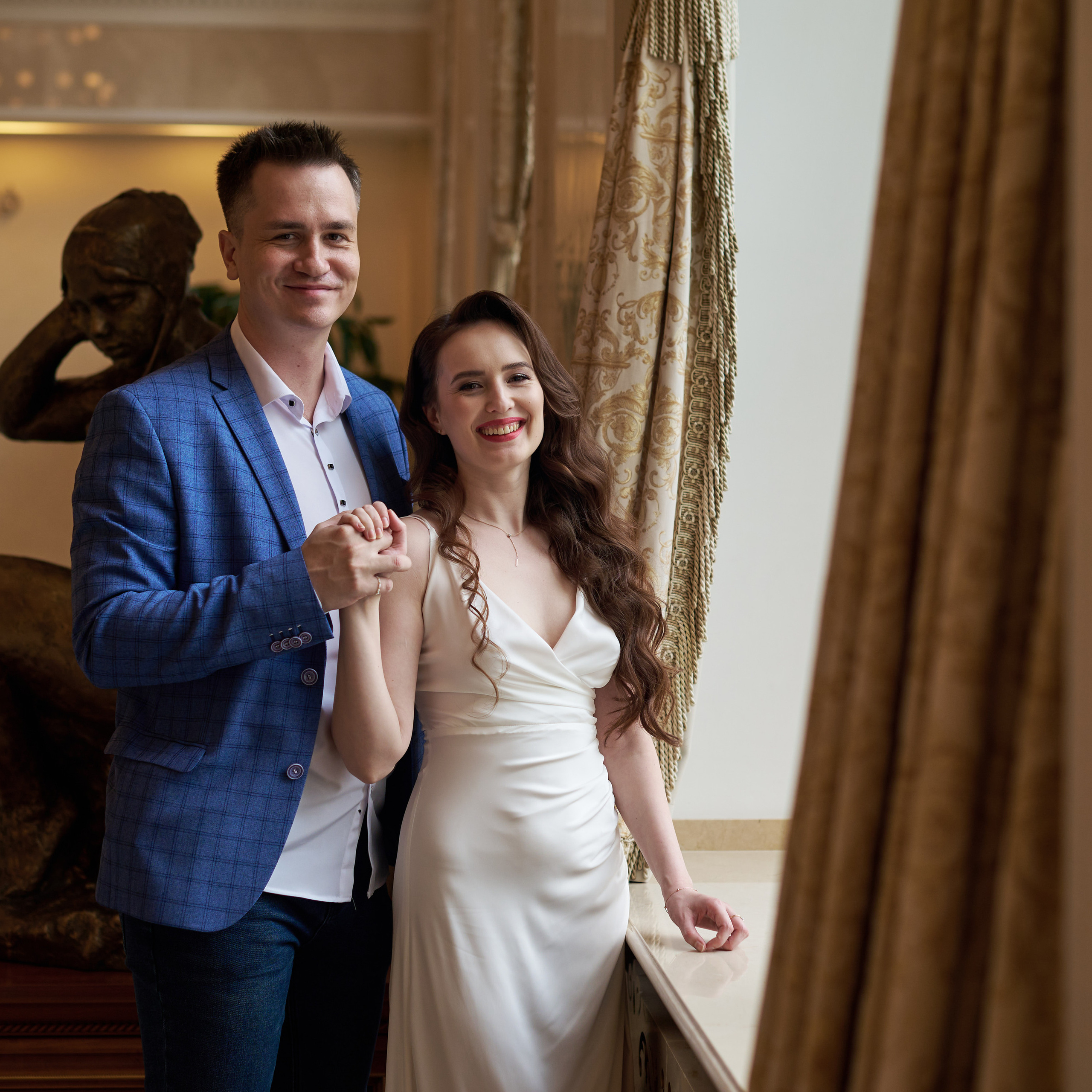 свадебное фото пары новобрачных у большого окна 