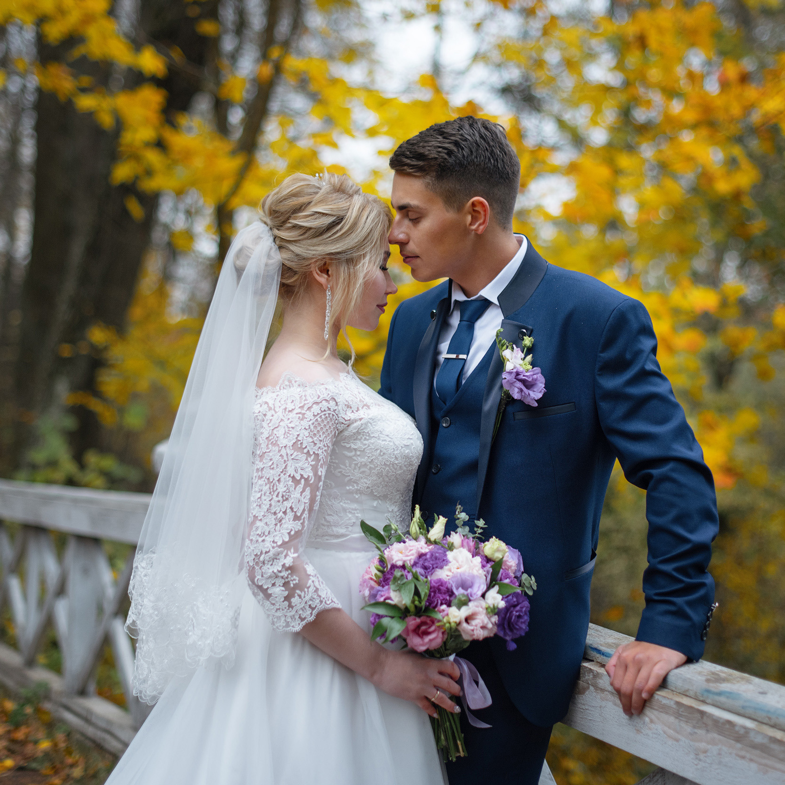 Свадебная пара на мосту в осеннем парке
