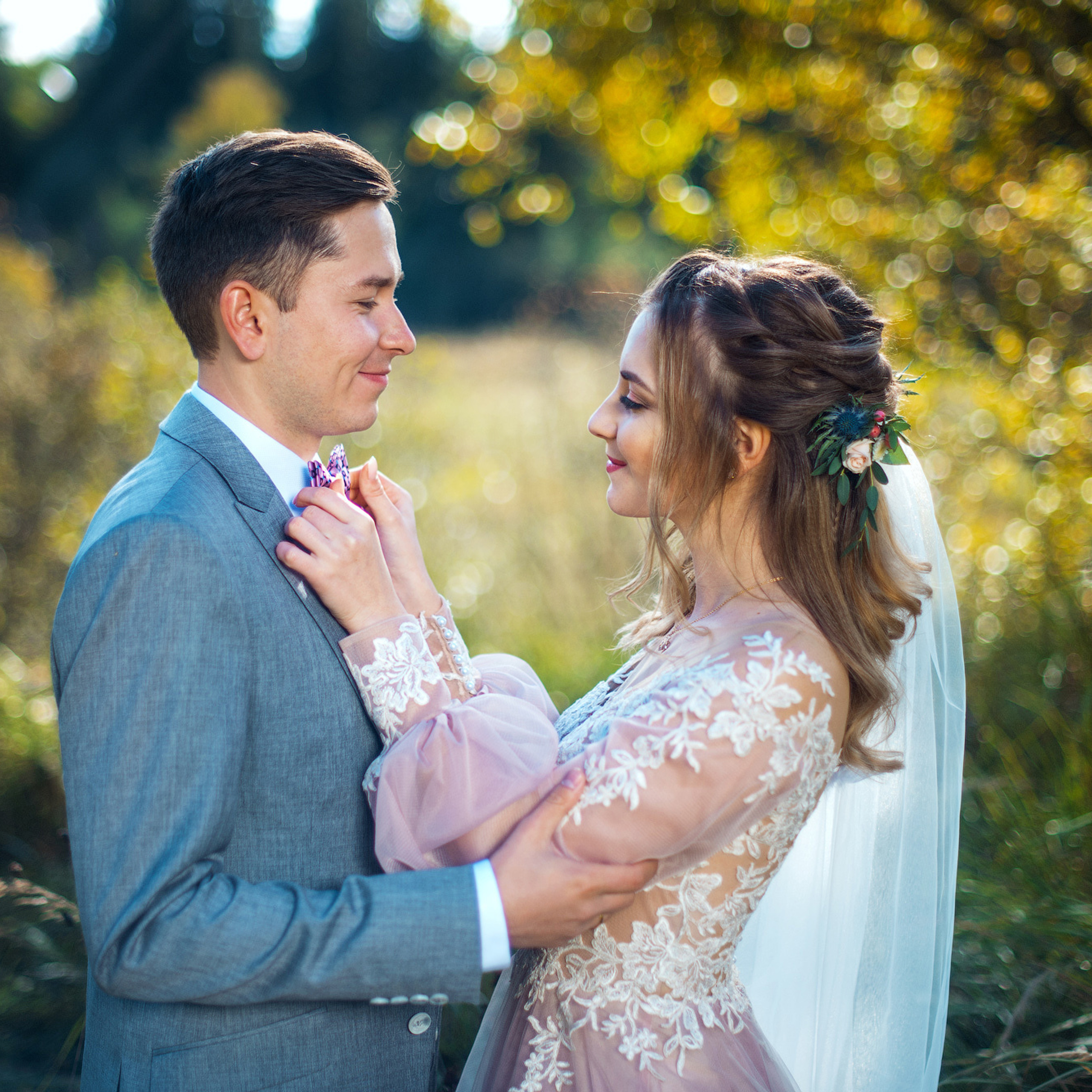 Жених держит за плечи нежную невесту и смотрит ей в глаза