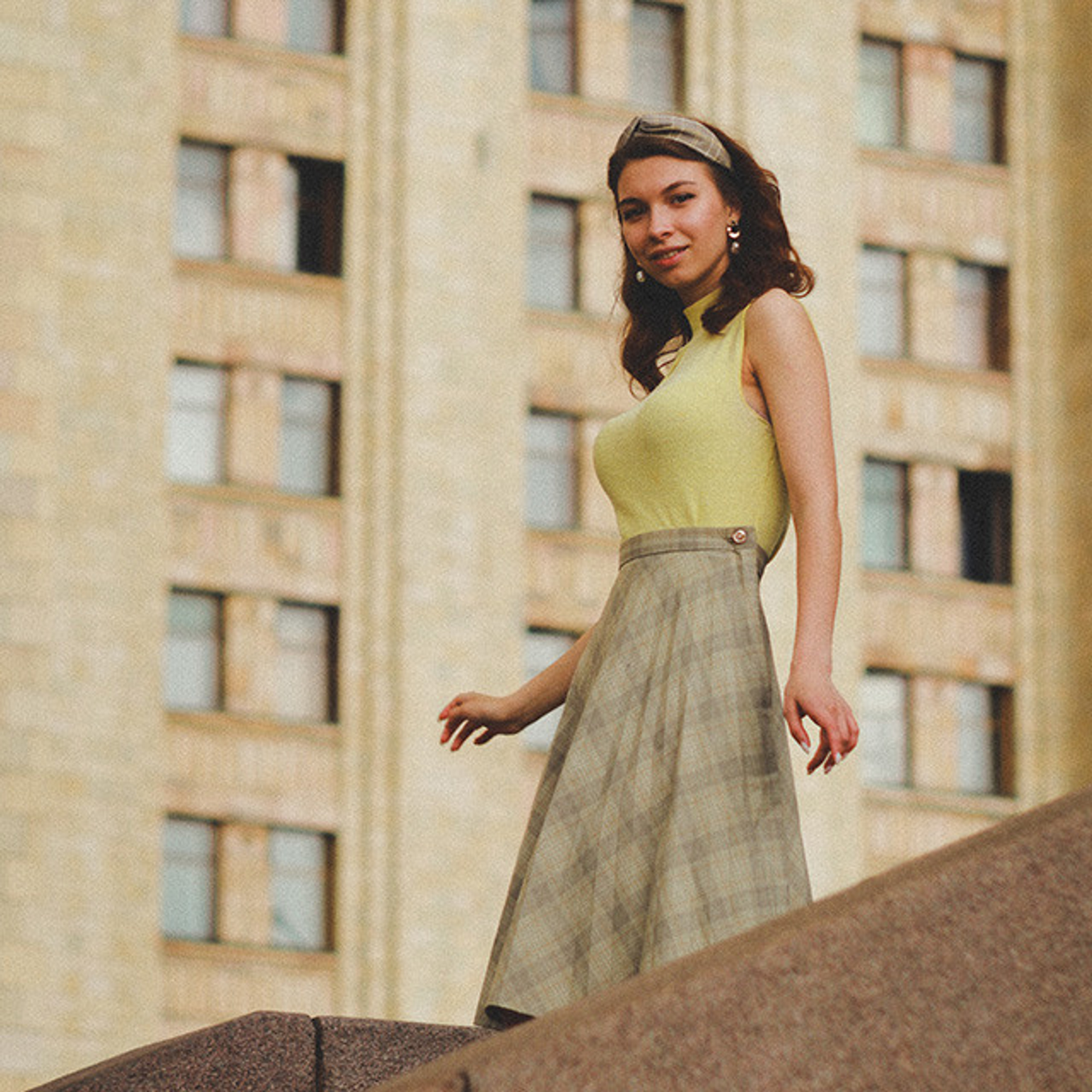 Сбегающая вниз по лестнице веселая девушка в образе репортажа снятого на пленку в пятидесятых годах