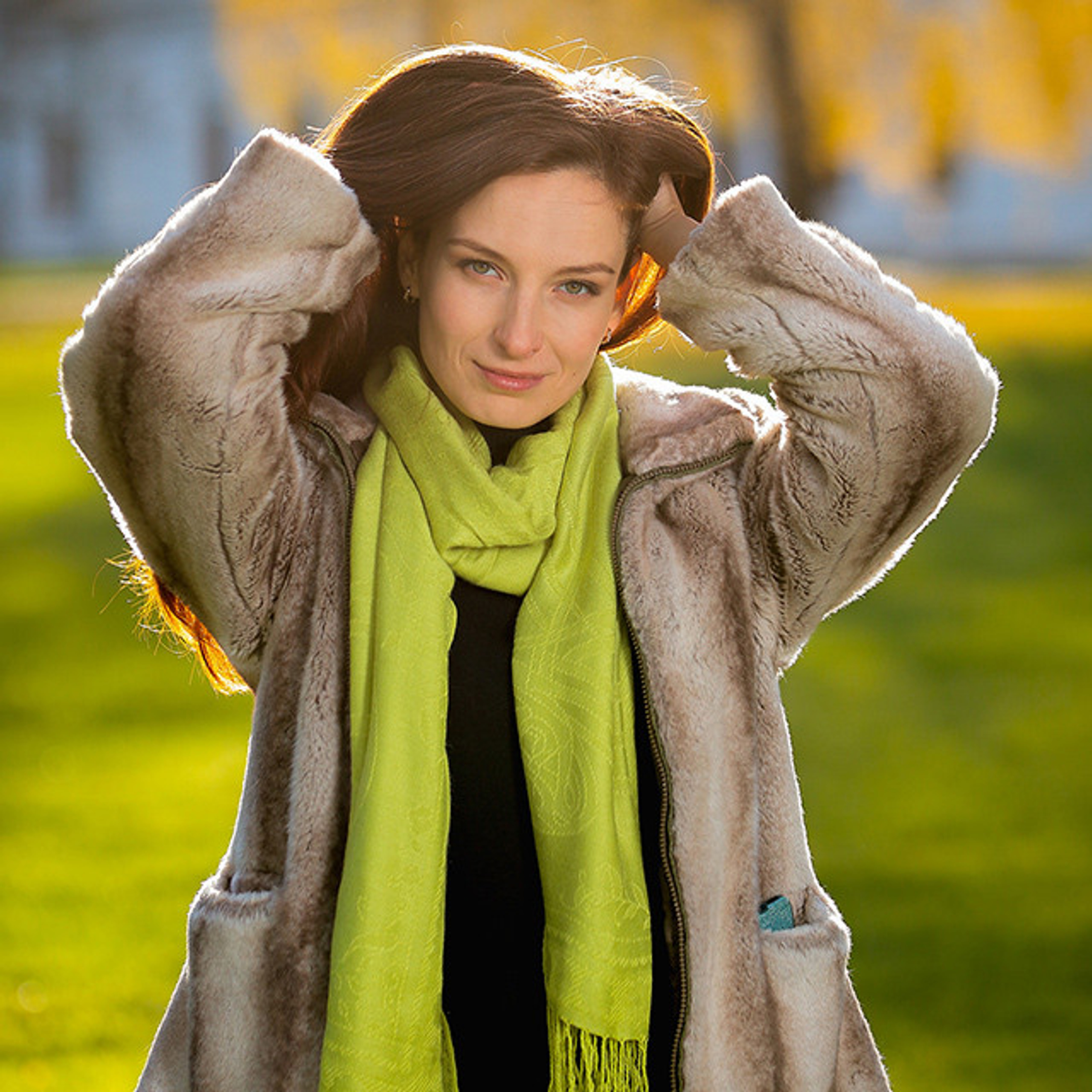 Модель в шубке запустившая руки в распущенные волосы