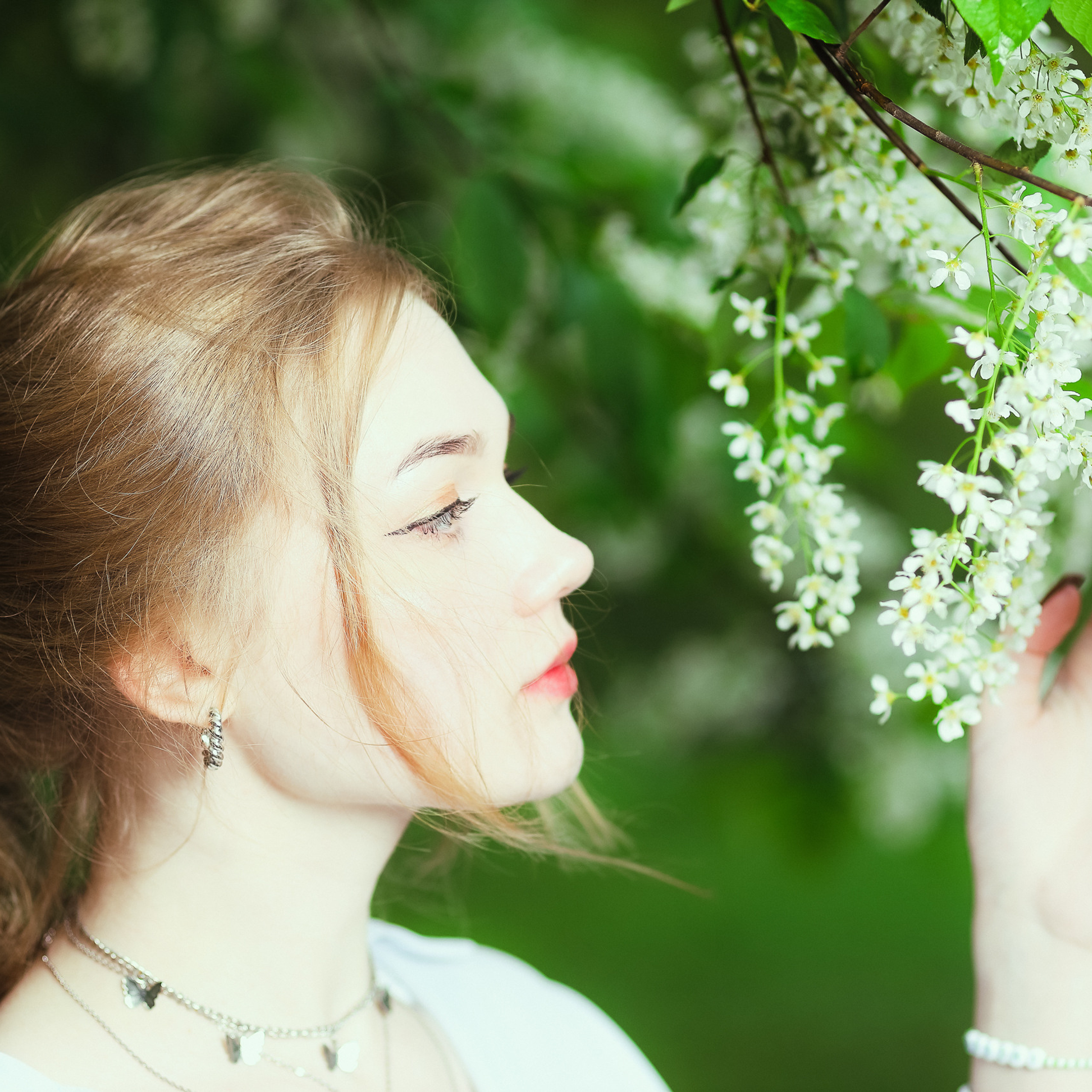 Портрет девушки в профиль с цветущей сиренью